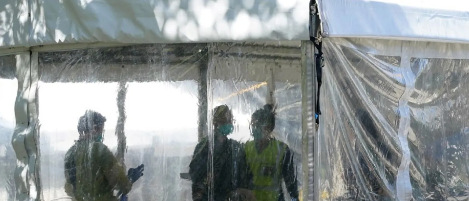 Health personnel work inside a coronavirus disease (COVID-19) vaccination clinic set up for residents of surrounding public housing towers in the Redfern suburb, where authorities are working to contain an emerging cluster of cases, as widespread lockdown continues in Sydney, Australia, September 17, 2021. REUTERS/Loren Elliott

