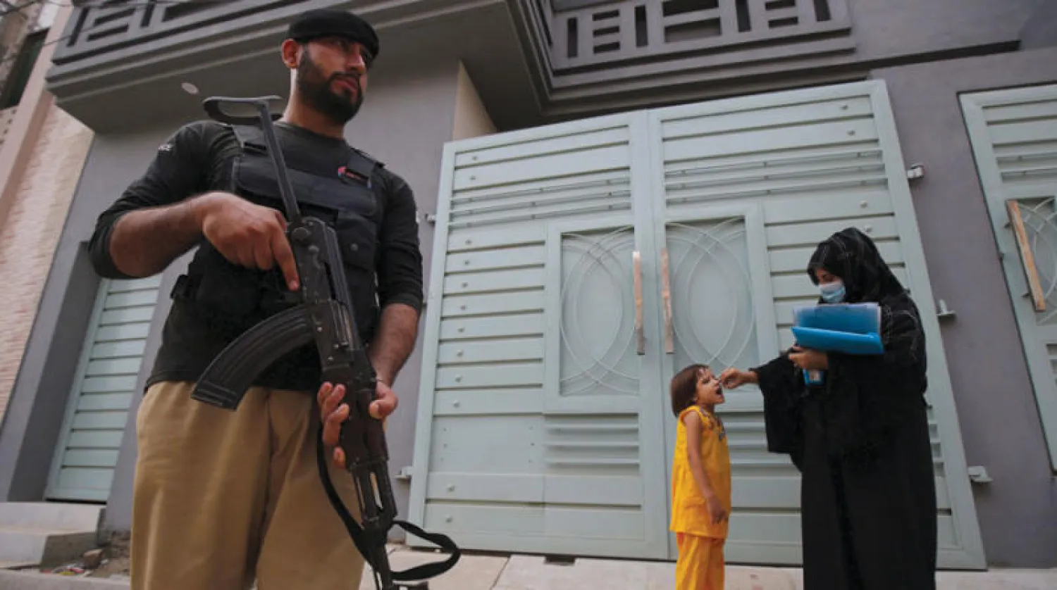 تحت الحراسة... تطعيم أطفال ضد شلل الأطفال في بيشاور أمس (إ.ب.أ)