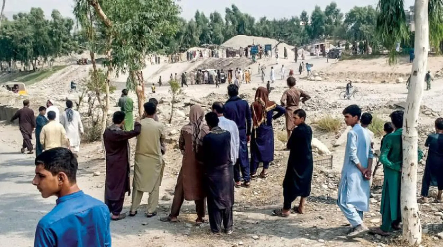 Taliban members and people gather at the site of a bomb explosion which targeted a pickup truck carrying Taliban fighters in Jalalabad on September 19, 2021. (Photo by - / AFP)