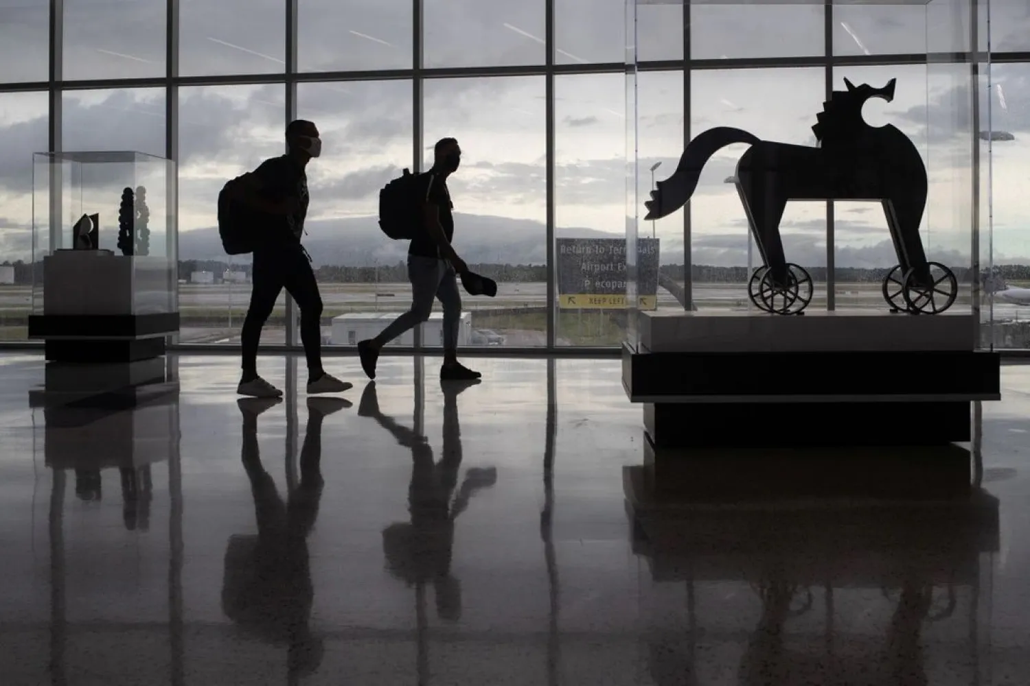 Passengers walk past artwork between terminals at IAH George Bush Intercontinental Airport amid the coronavirus disease (COVID-19) outbreak in Houston, Texas, US, July 21, 2020. (Reuters)