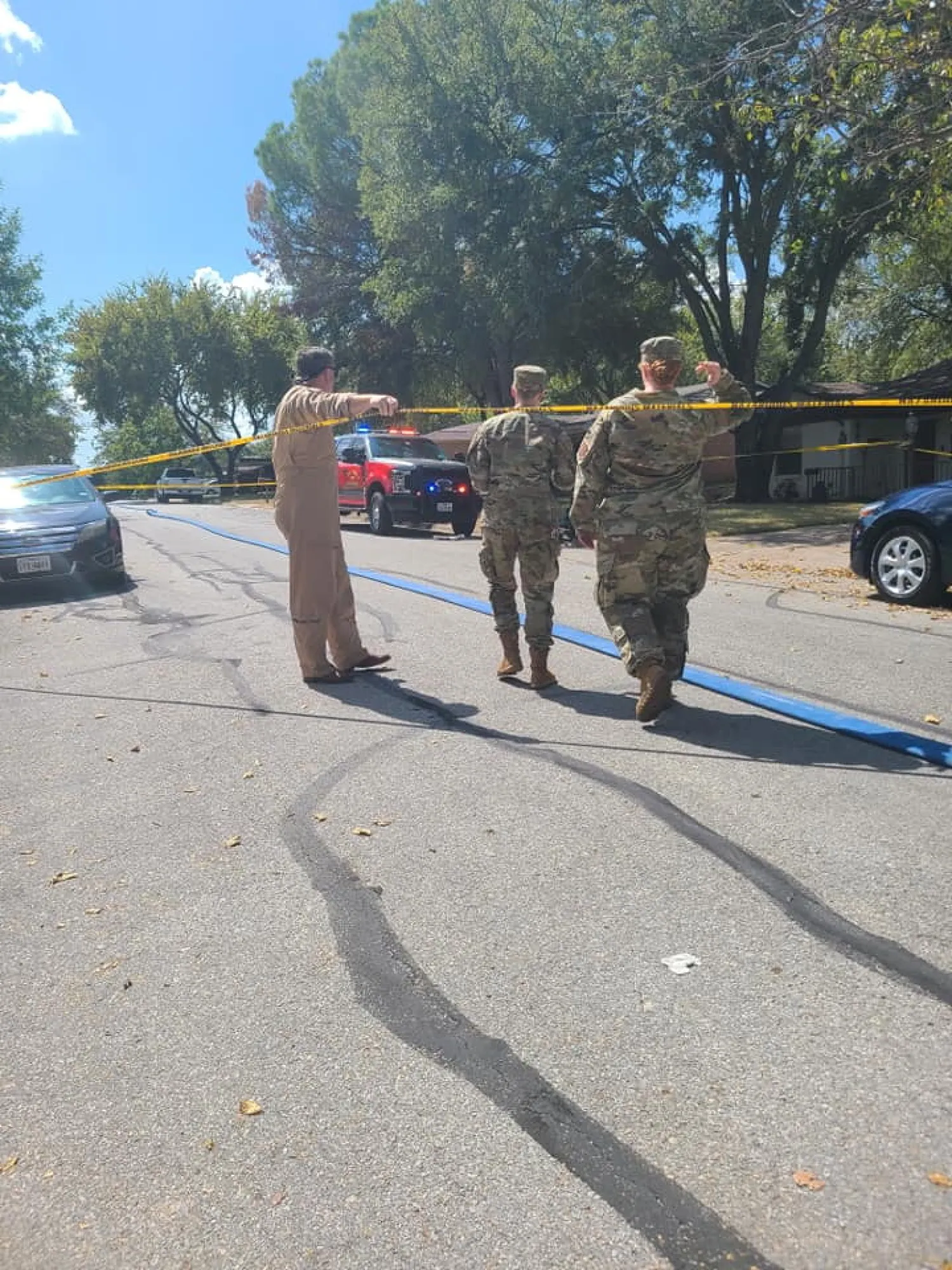 Military personnel walk near the site where a military training aircraft crashed into a residential neighborhood in Lake Worth, Texas, US September 19, 2021 in this image obtained from social media. Joni Scarbrough/via REUTERS 