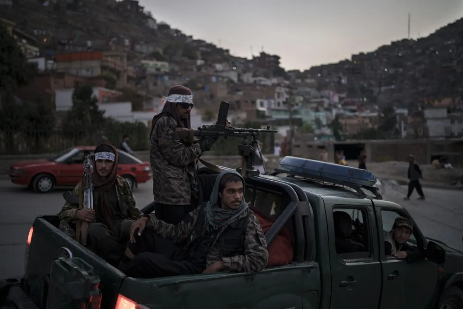 Taliban fighters sit on the back of a pickup truck as they stop on a hillside in Kabul, Afghanistan, Sunday, Sept. 19, 2021. (AP Photo/Felipe Dana)
