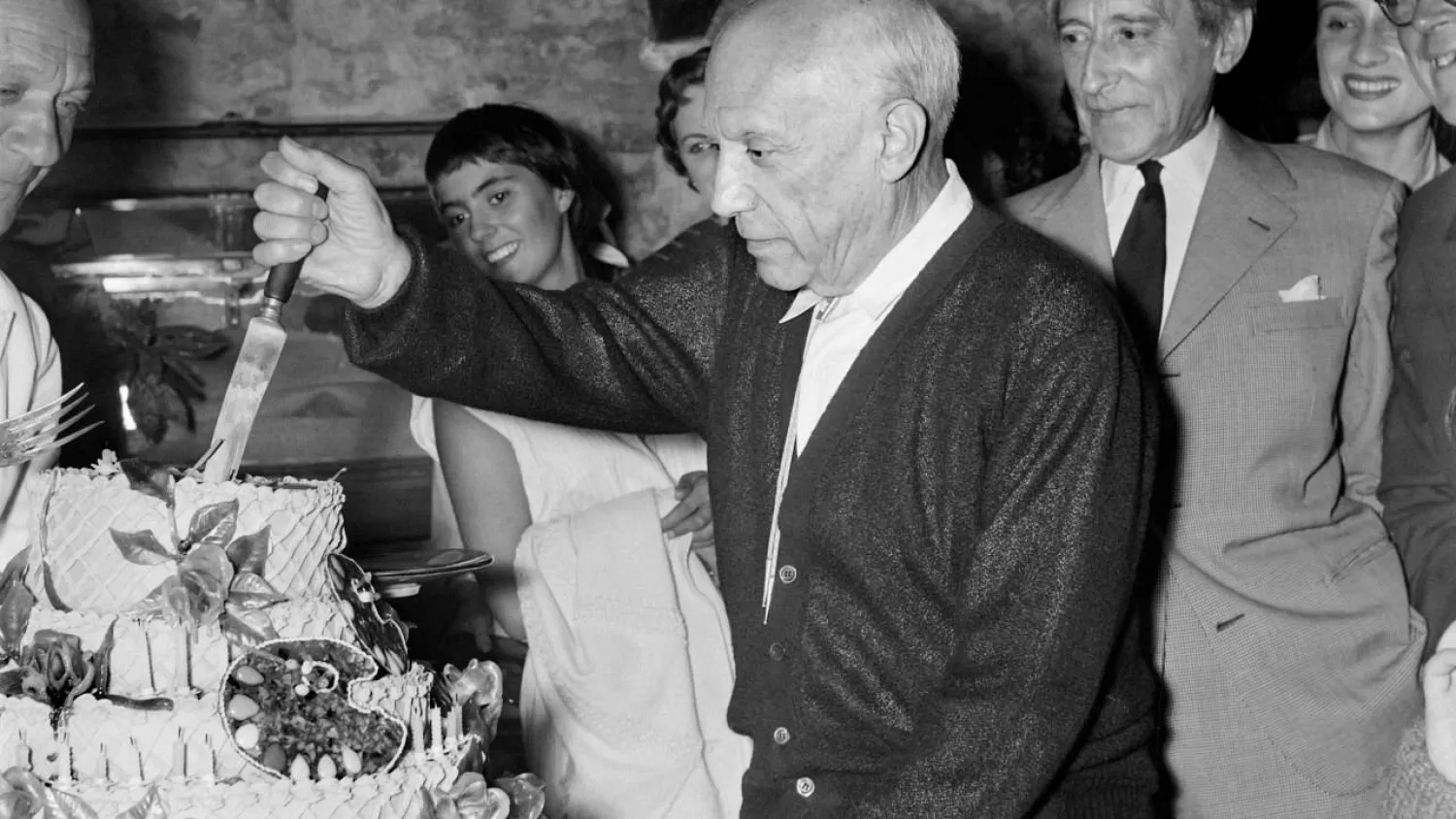 Spanish painter Pablo Picasso, flanked by his French friend poet Jean Cocteau (R), cuts his cake for his 75th birthday on October 25, 1956 in Vallauris.   -  Copyright  JEAN MEUNIER/AFP