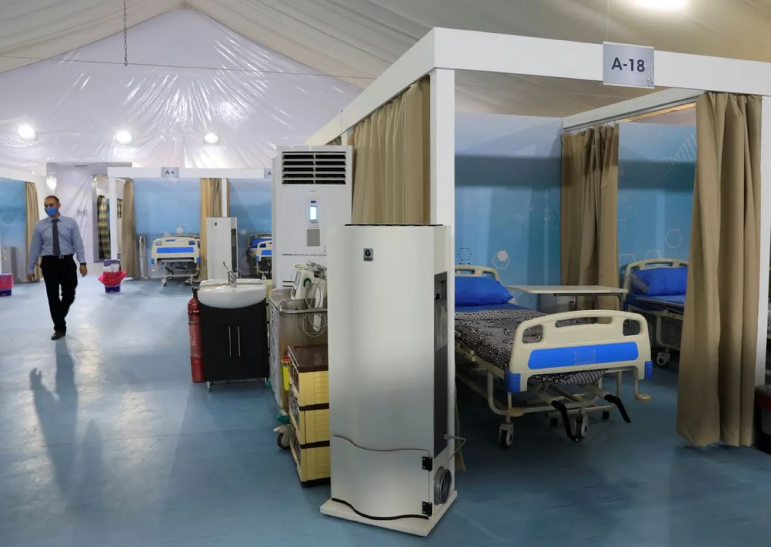 An employee wearing a protective face mask, amid concerns over the coronavirus disease (COVID-19) walks next to beds at the Ain Shams field hospital prepared to receive COVID-19 patients in Cairo, Egypt June 16, 2020. REUTERS/Amr Abdallah Dalsh
