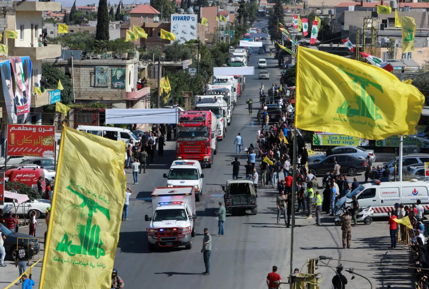 Hezbollah flags fly above a convoy of tanker trucks carrying Iranian fuel oil arriving at al-Ain village in northeastern Lebanon, 16 September 2021 (Reuters)