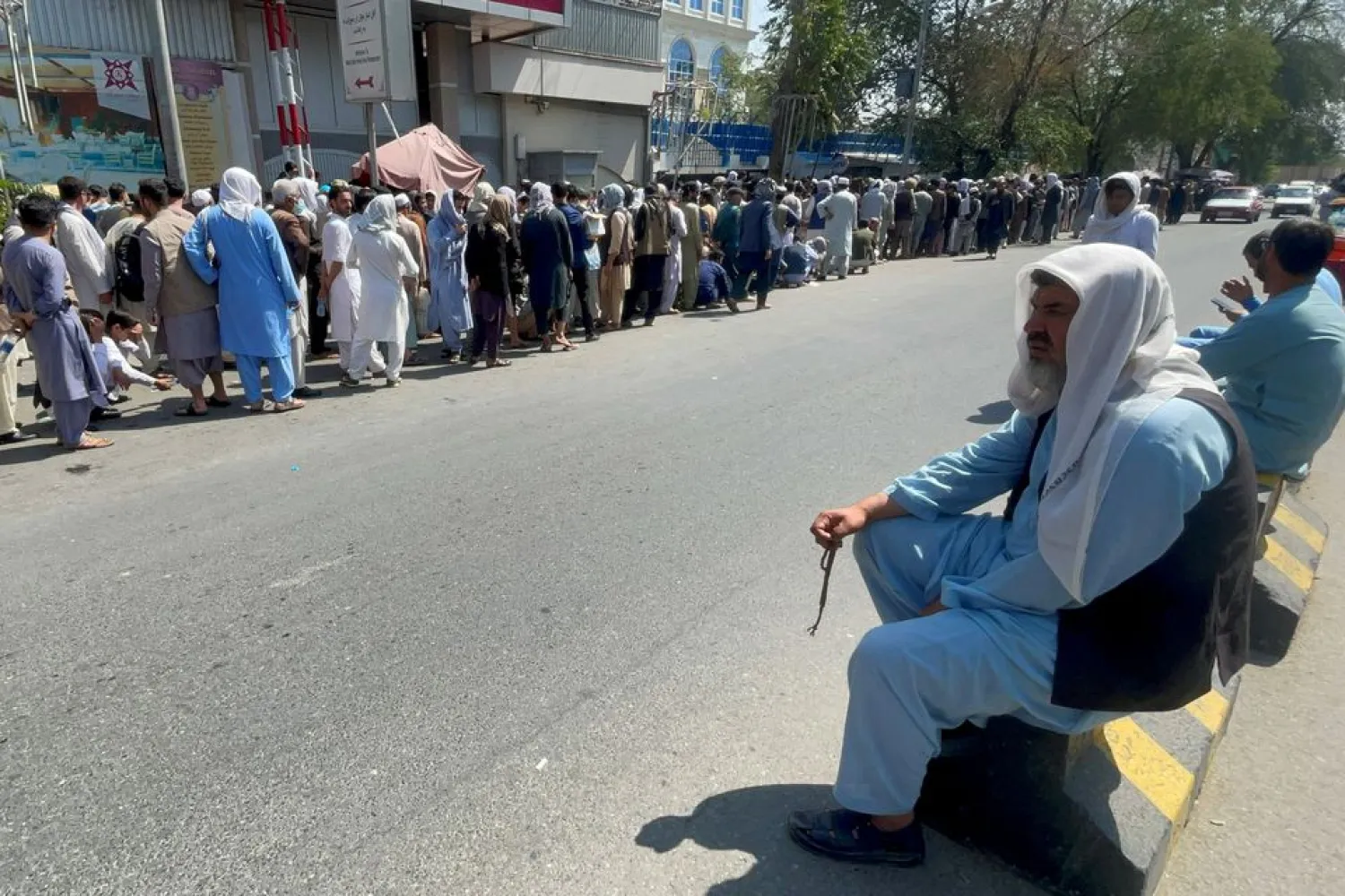 Afghans line up outside a bank to take out their money after Taliban takeover in Kabul, Afghanistan September 1, 2021. (Reuters)