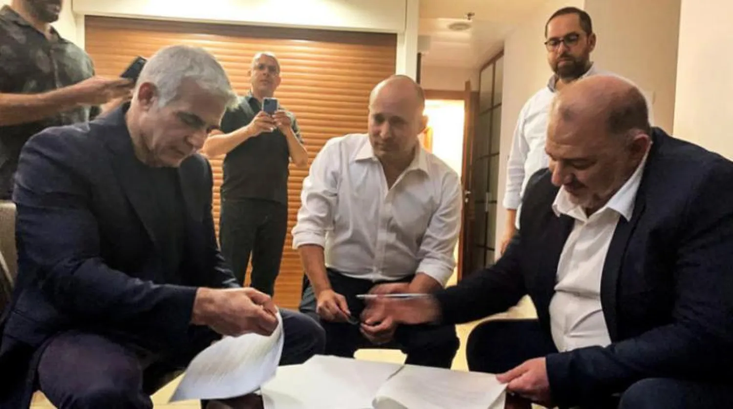 Birleşik Arap Listesi lideri Abbas (sağda) geçen haziran ayında Bennett (ortada) ve Lapid ile koalisyon hükümeti anlaşmasını imzaladı. (Reuters)