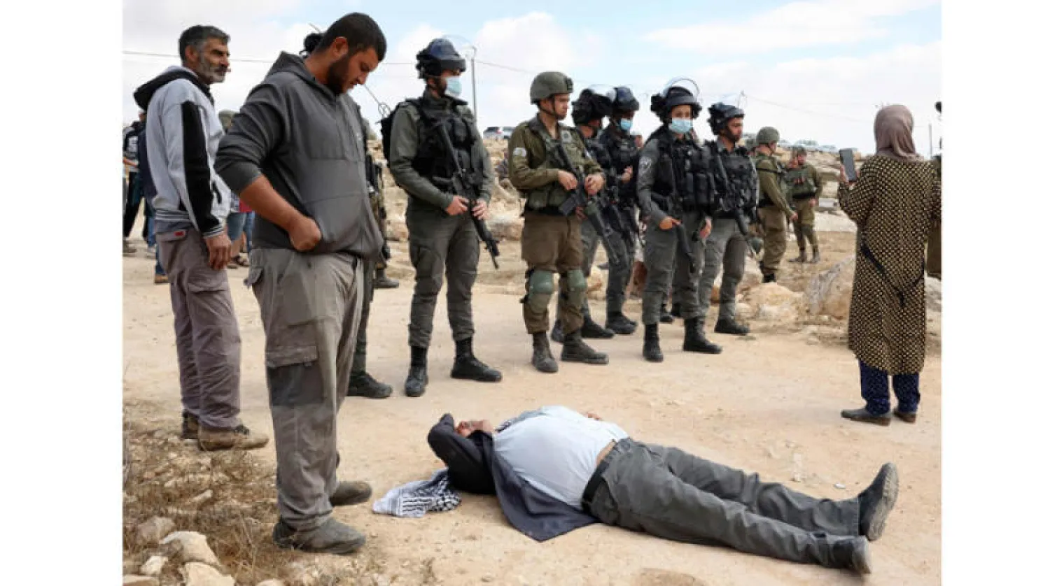 فلسطيني على الأرض محاطاً بقوات إسرائيلية خلال مواجهات في قرية سوسيا بالضفة (أ.ف.ب)