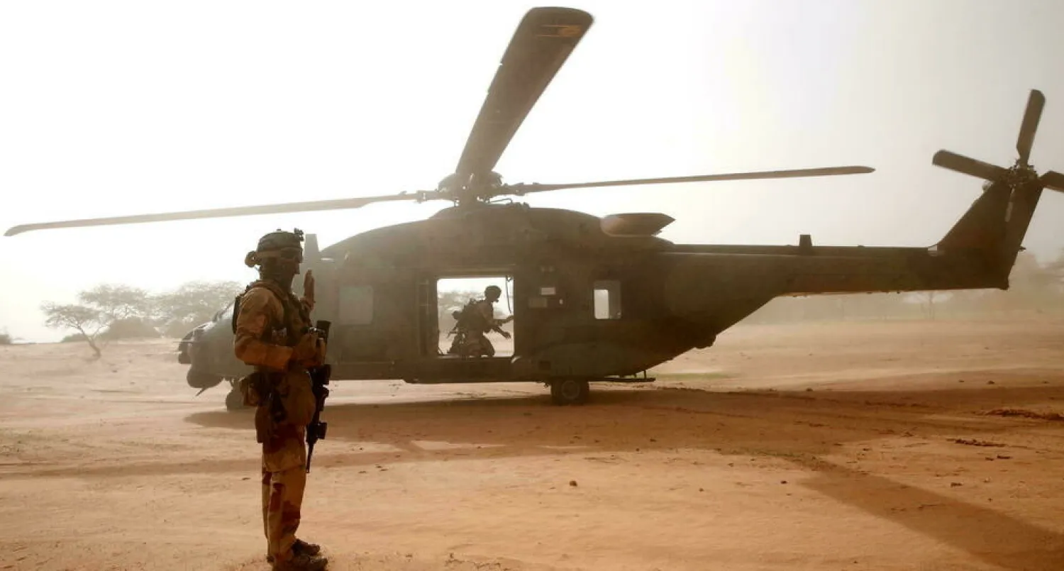 A French soldier stands guard in front of an NH90 Caiman military helicopter during Operation Barkhane in Ndaki, Mali, on July 29, 2019. © Benoit Tessier, REUTERS
