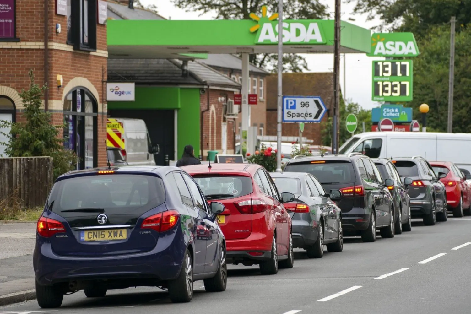 Cars queue outside a petrol station in England. Photo: AP
