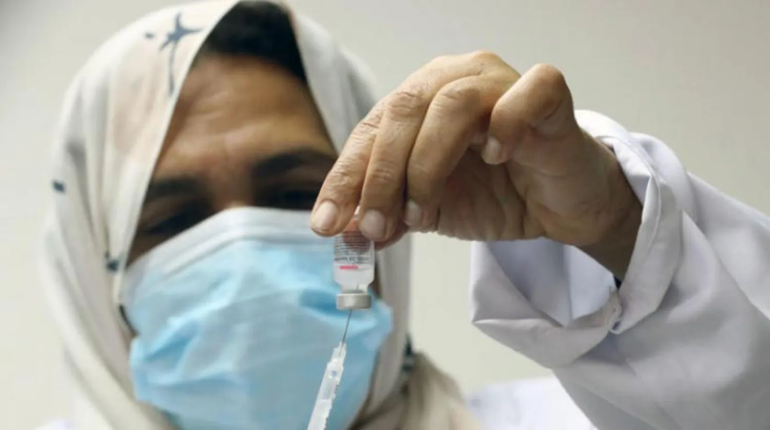 A nurse prepares a dose of the coronavirus vaccine at a vaccination center at Cairo University (EPA)