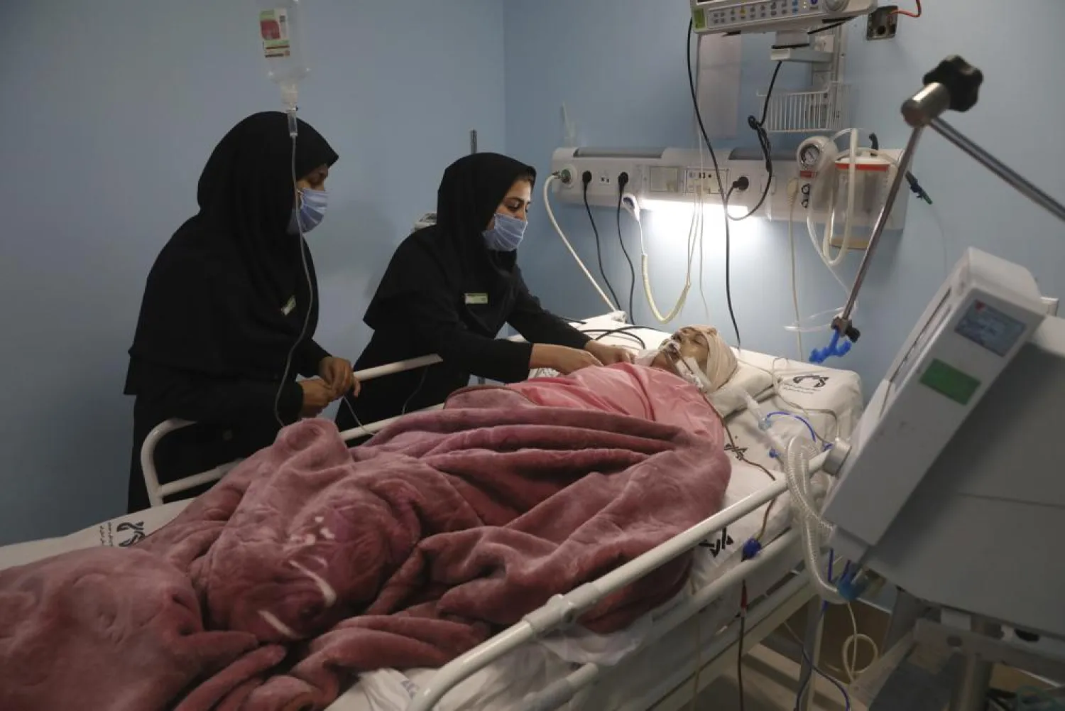Covid-19 patient Marhamat Asadi which is in medically induced coma is tended by nurses Fatemeh Najmeh Sadeghi, left, and Fereshteh Babakhanlou at the COVID-19 ICU ward of Amir Al-Momenin hospital in the city of Qom, some 80 miles (125 kilometers) south of the capital Tehran, Iran, Wednesday, Sept. 15, 2021. (AP Photo/Vahid Salemi)
