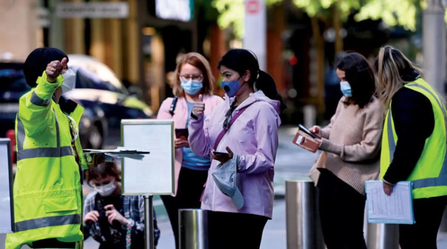 أستراليات يضعن كمامات أمام مركز للتلقيح في سيدني (إ.ب.أ)