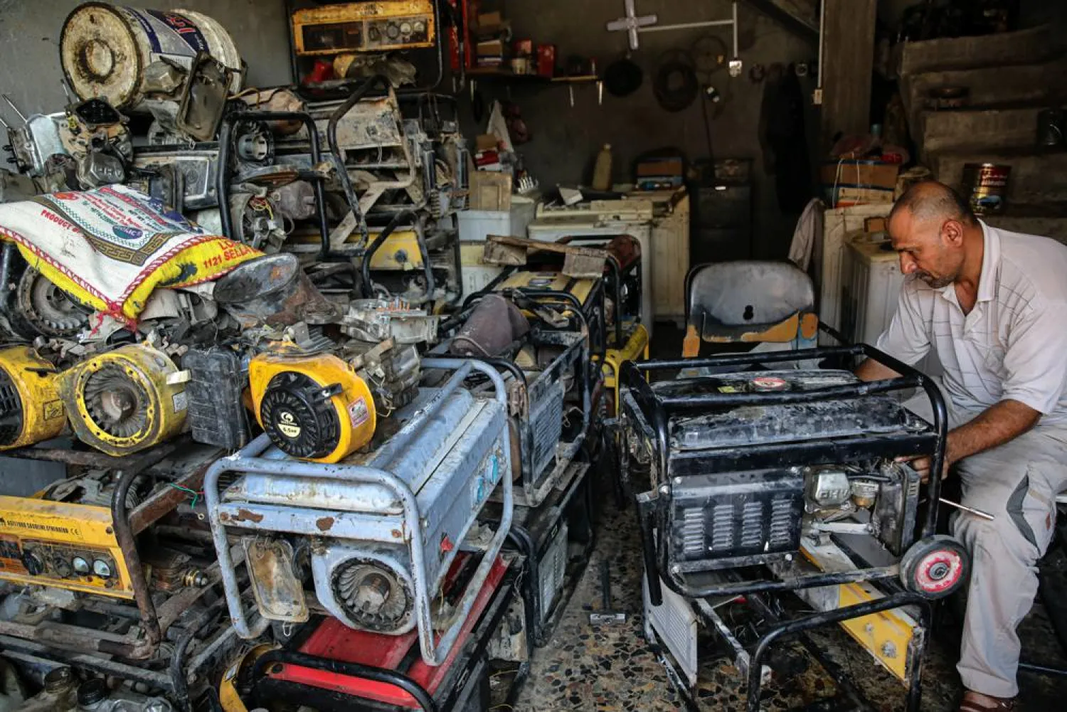 A worker repairs generators at his shop in Basra, Iraq, Tuesday, July 29, 2021. (AP)