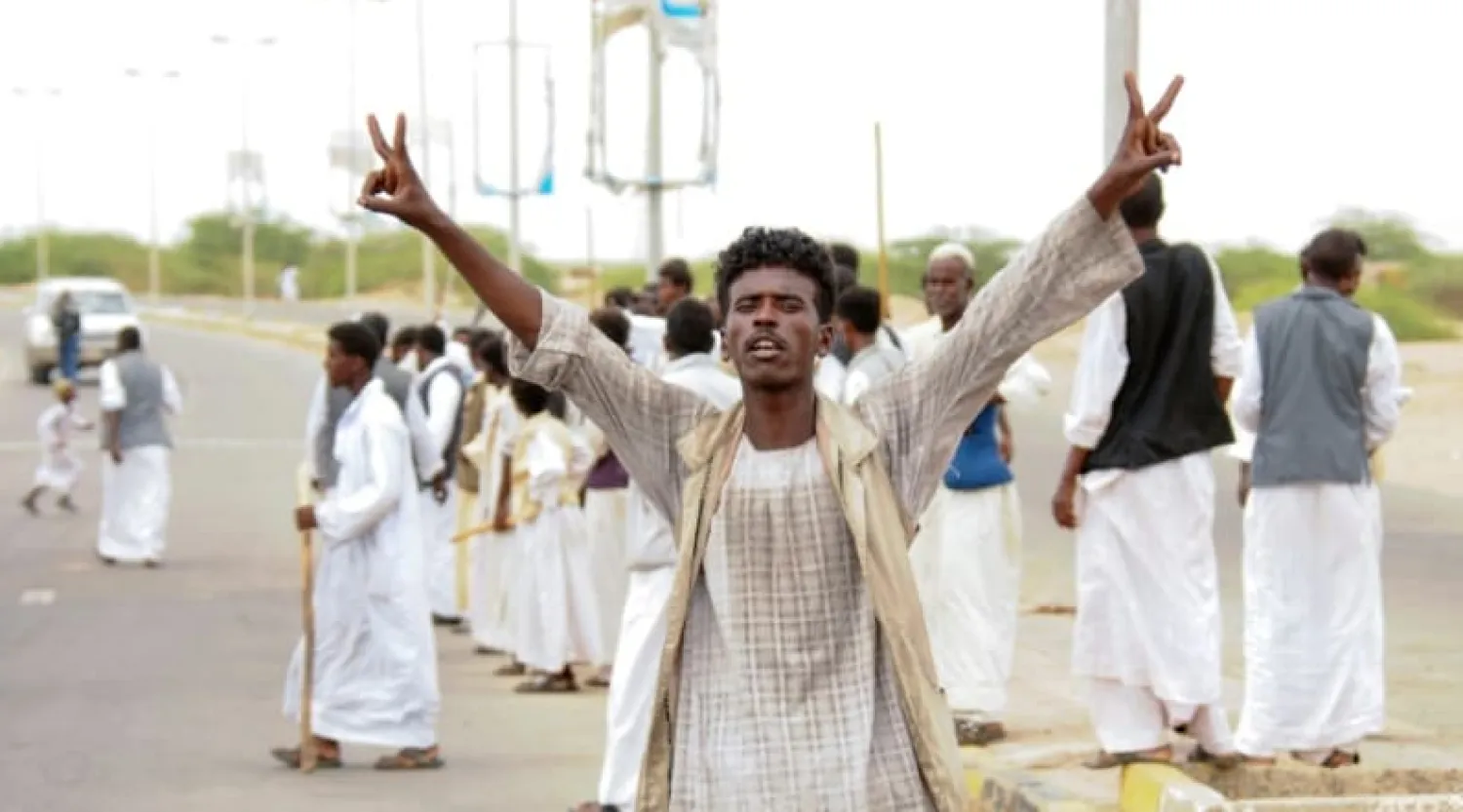 A protester flashes victory signs as supporters of Sudan's head of the Supreme Council of Beja Prefectures and Independent Umudiyyahs rally, following the arrival of a delegationg led by a member of the country's sovereign council in the city of Port Sudan, on September 26, 2021. (AFP)
