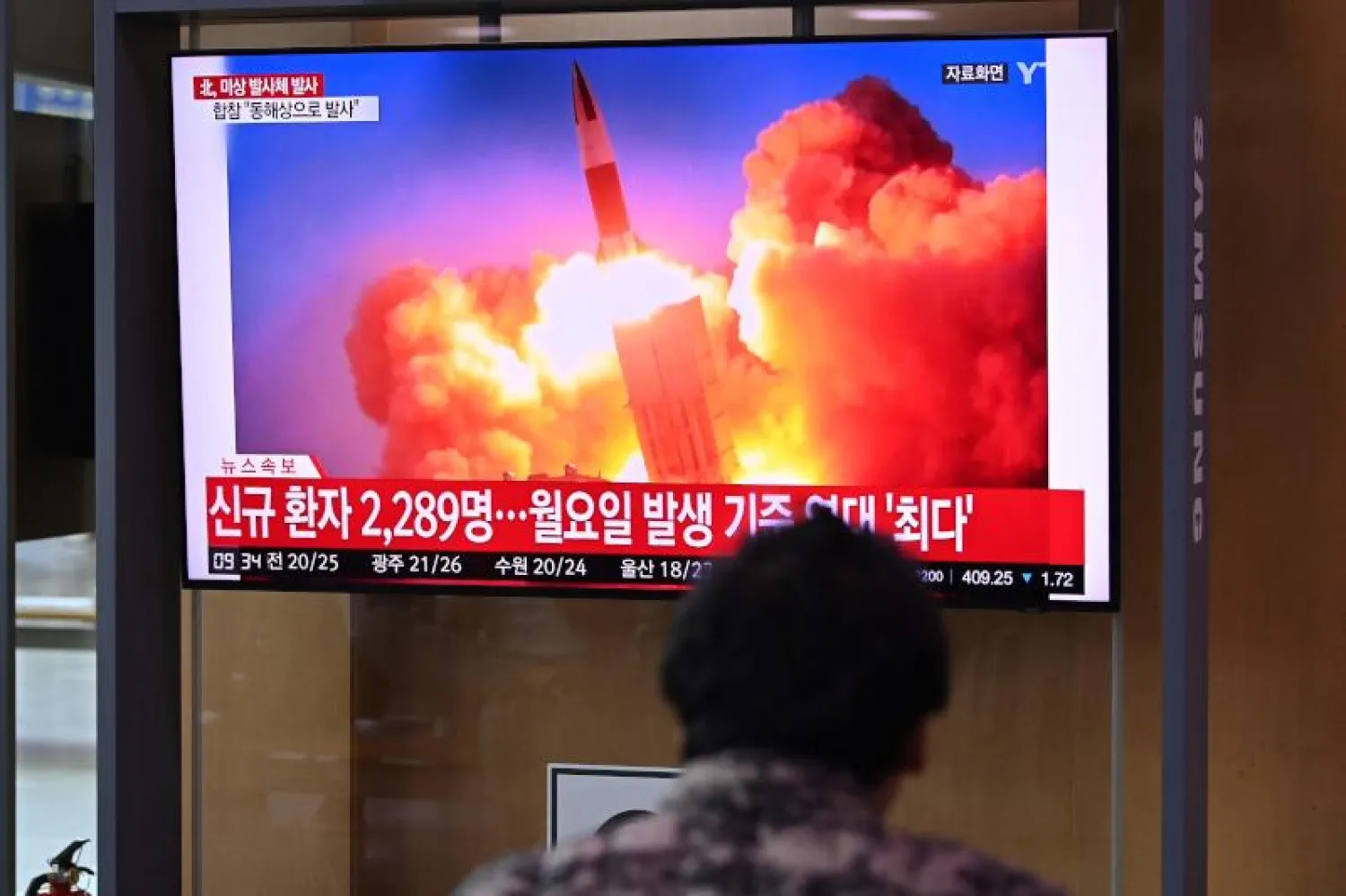 مواطن يشاهد عملية إطلاق الصاروخ التي تمت من إقليم جاجانغ في كوريا الشمالية (أ.ف.ب)