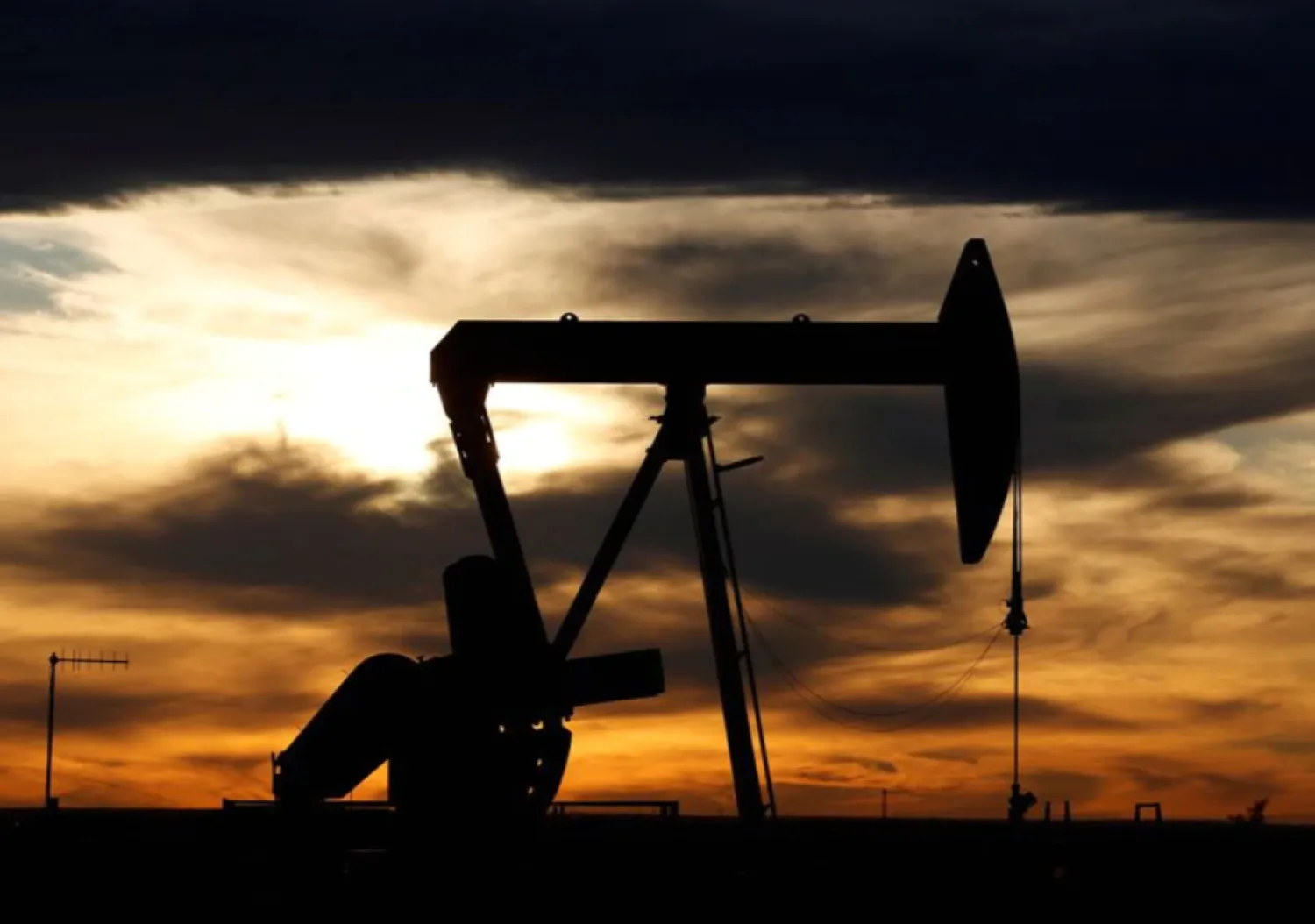 The sun sets behind a crude oil pump jack on a drill pad in the Permian Basin in Loving County, Texas, U.S. November 24, 2019. REUTERS/Angus Mordant