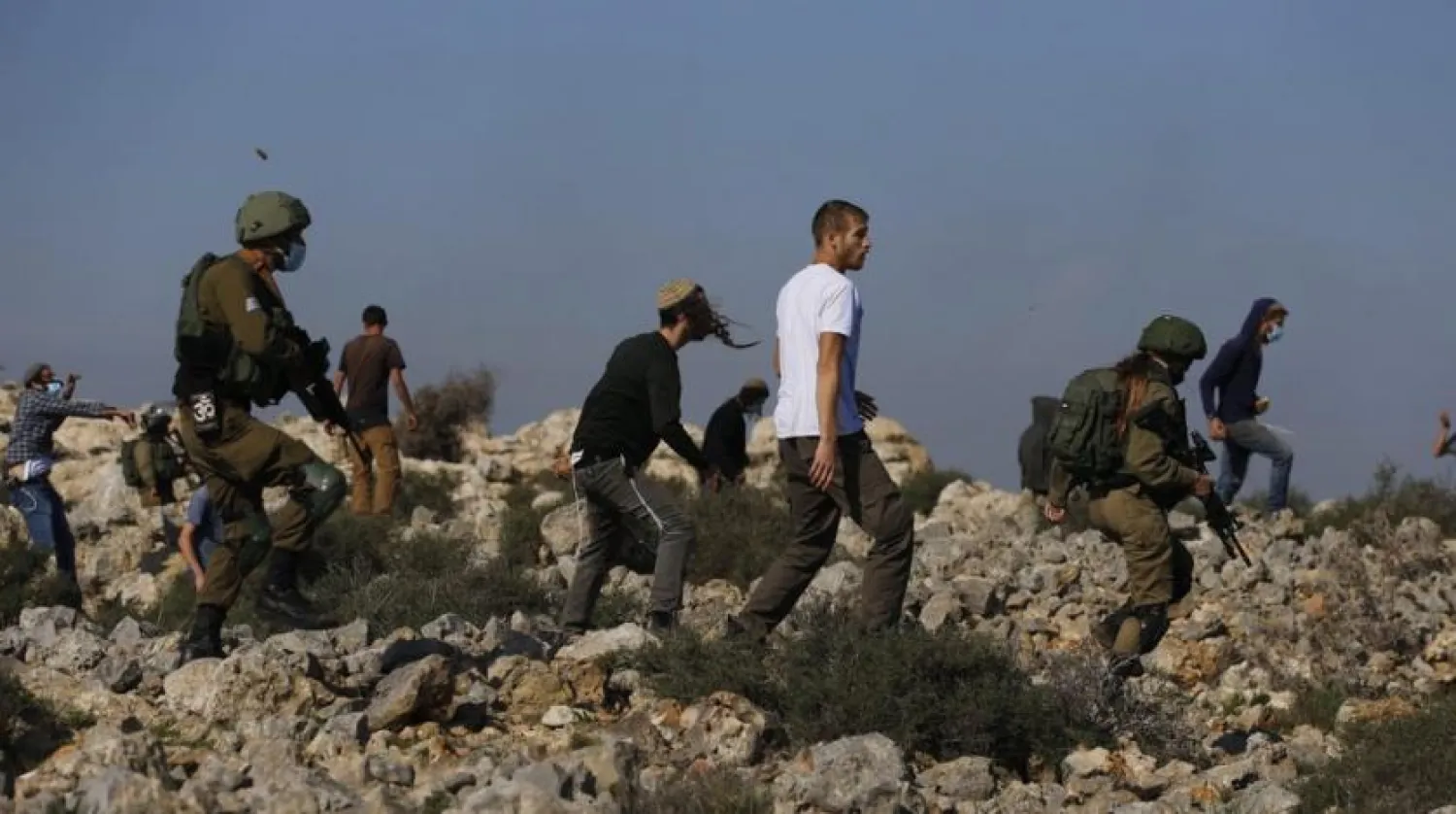 Israeli soldiers and settlers clash with Palestinians during a protest against the expansion of Jewish settlements near the West Bank town of Salfit, Monday, Nov. 30, 2020. (AP Photo/Majdi Mohammed)
