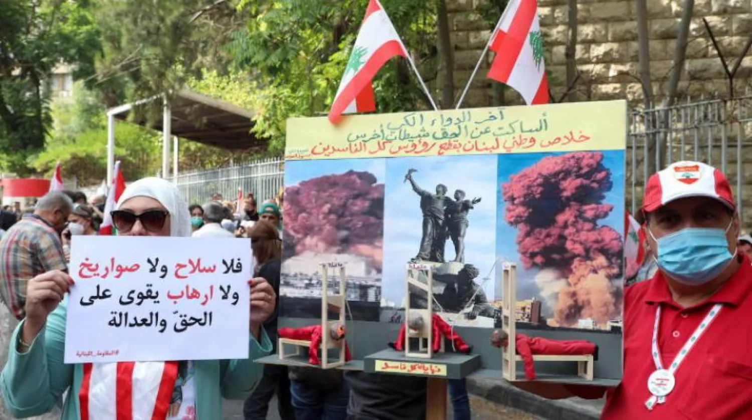 Beyrut'taki Adalet Sarayı önünde düzenlenen gösteride protestocular pankart taşıyor (Reuters)
