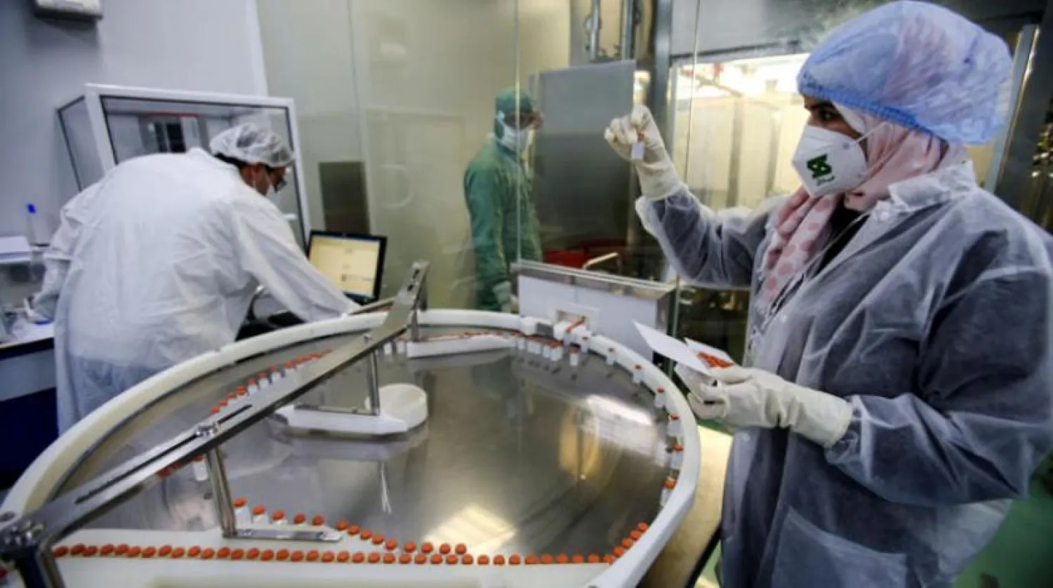A lab technician holds a vial of Chinese Sinovac's CoronaVac vaccine against coronavirus disease (COVID-19) during the inauguration of a production lab designated to manufacture the vaccine, in Constantine, Algeria September 29, 2021. REUTERS/Ramzi Boudina