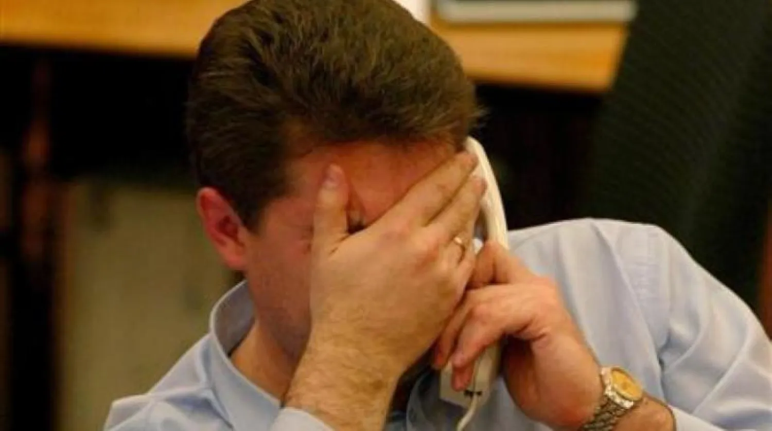 شخص يتحدث في الهاتف يبدو عليه الضيق (أرشيفية - رويترز)