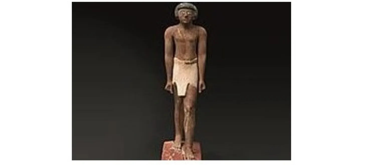 تمثال من الحجر الجيري لرجل يقف مرتكزاً على قاعدة