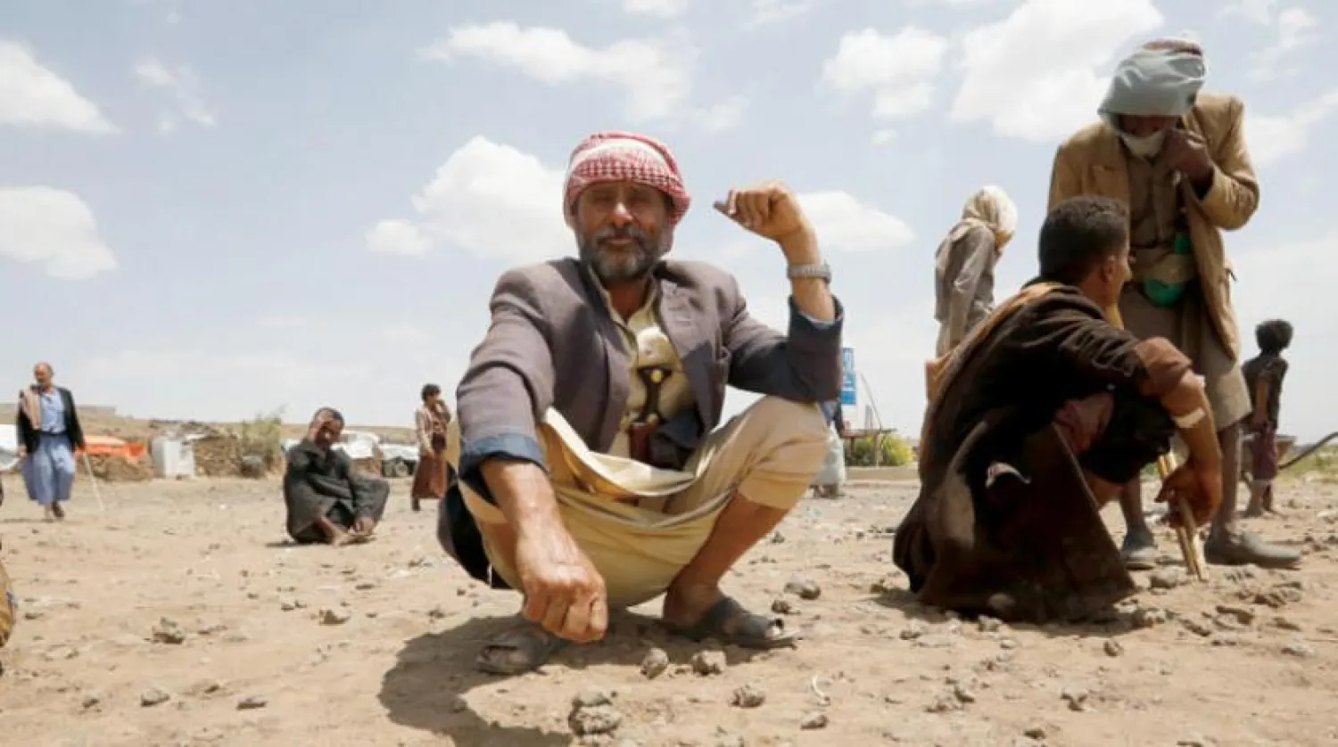A displaced Yemeni waits for his share of food aid in a camp for displaced people in Sanaa (EPA)
