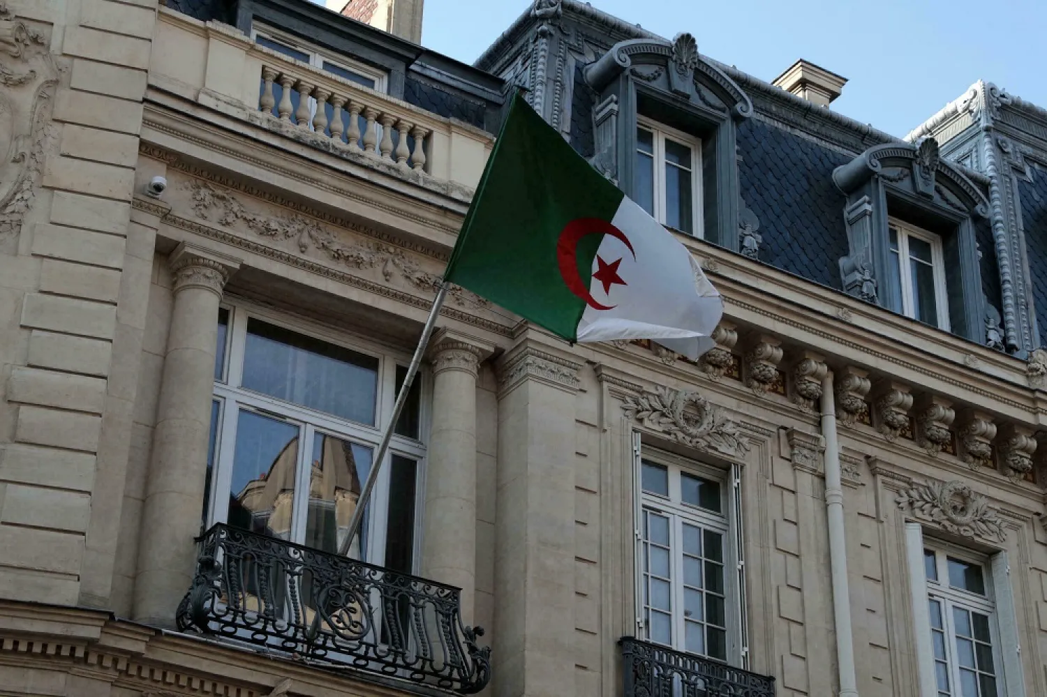 An Algerian flag flutters on the façade of the embassy in Paris in July 2021. (AFP)