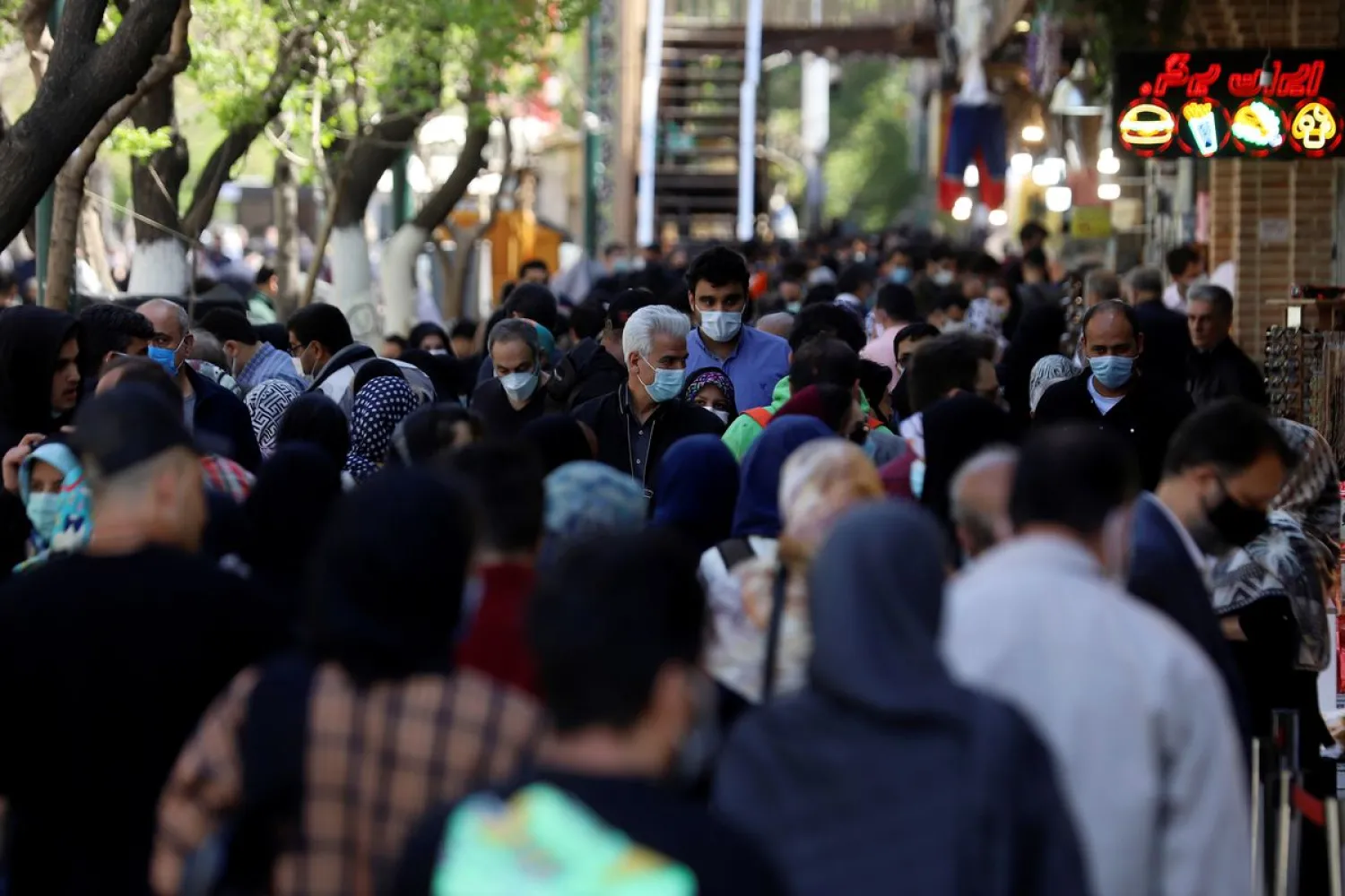 Iranian people wear protective face masks, as they walk amid the spread of the coronavirus disease (COVID-19), in Tehran, Iran March 30, 2021. Picture taken March 30, 2021. (Reuters)