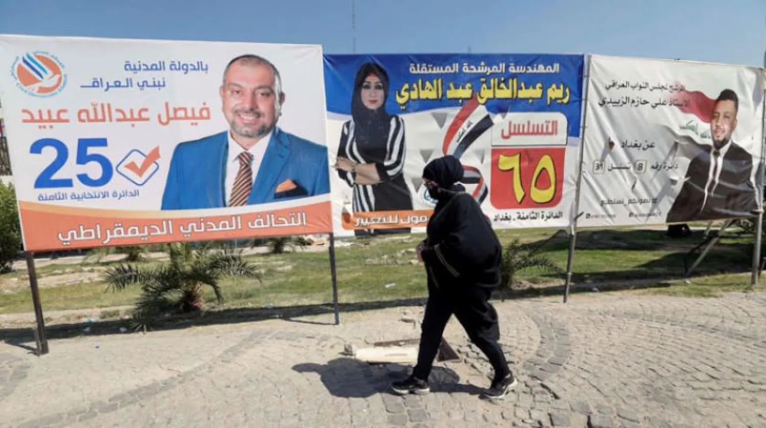 ایک عراقی خاتون کو کل بغداد میں انتخابی پوسٹروں کے سامنے سے گزرتے ہوئے دیکھا جا سکتا ہے (رائٹرز)