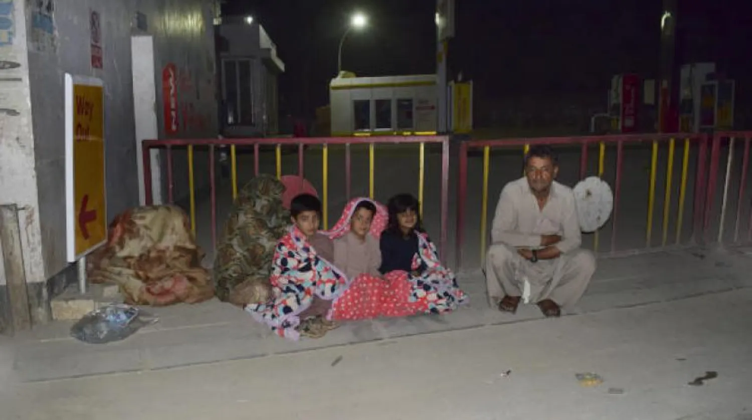 Pakistan'ın güneyindeki Ketta'da şiddetli bir depremin ardından bir aile evlerinin önünde bekliyor (AP)
