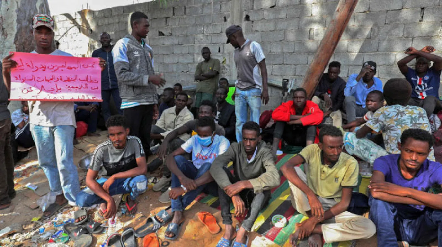 مهاجرون خلال تظاهرة نظموها أمام مقر «مفوضية اللاجئين» في طرابلس أمس (أ.ف.ب)