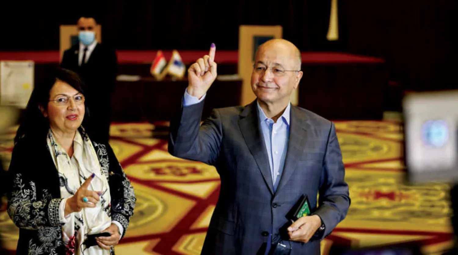 الرئيس العراقي برهم صالح وعقيلته بعد اقتراعهما أمس (رويترز).