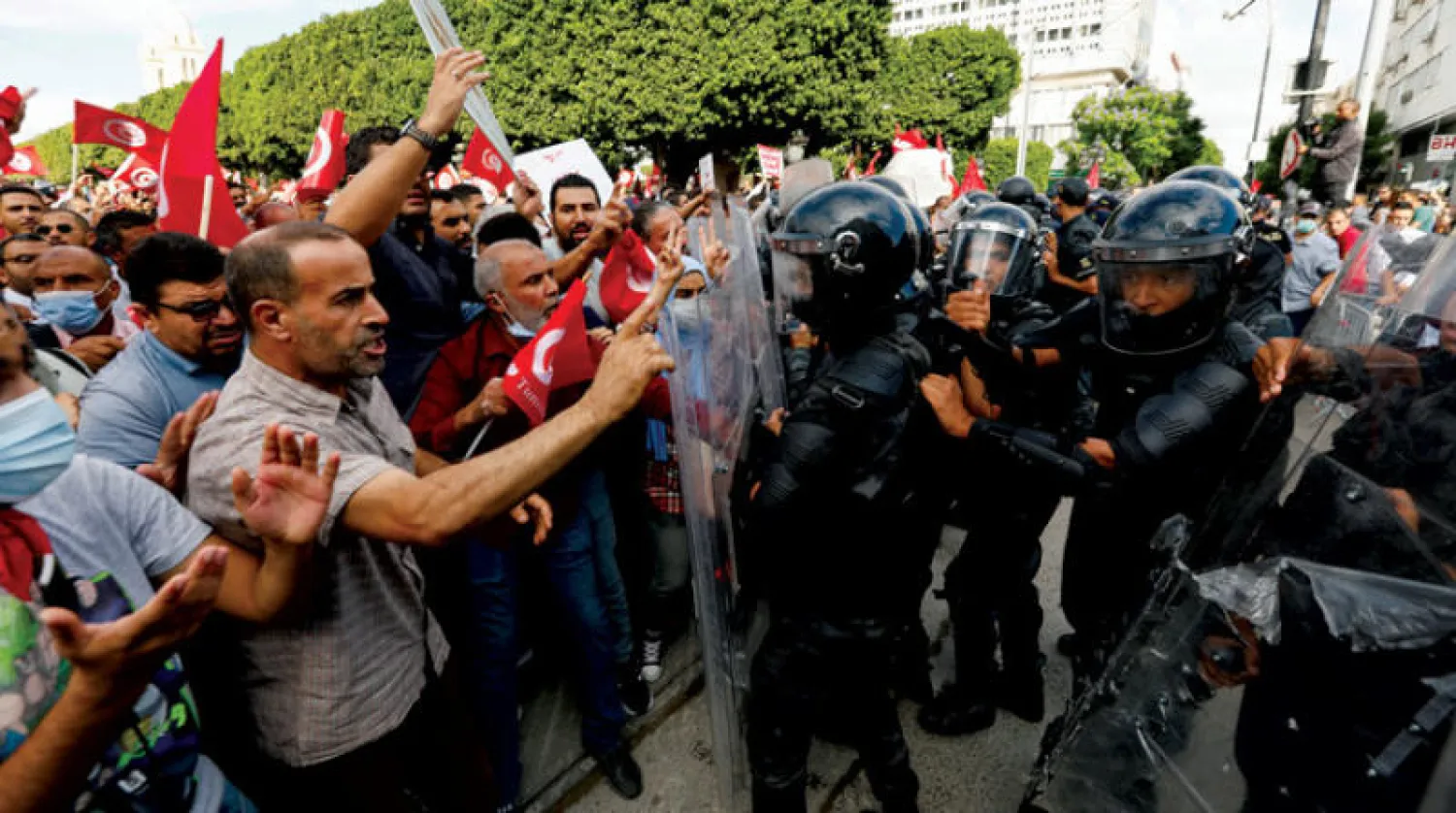 اشتباكات بين متظاهرين مناهضين لـ«التدابير الرئاسية» والأمن في العاصمة تونس أمس (رويترز)