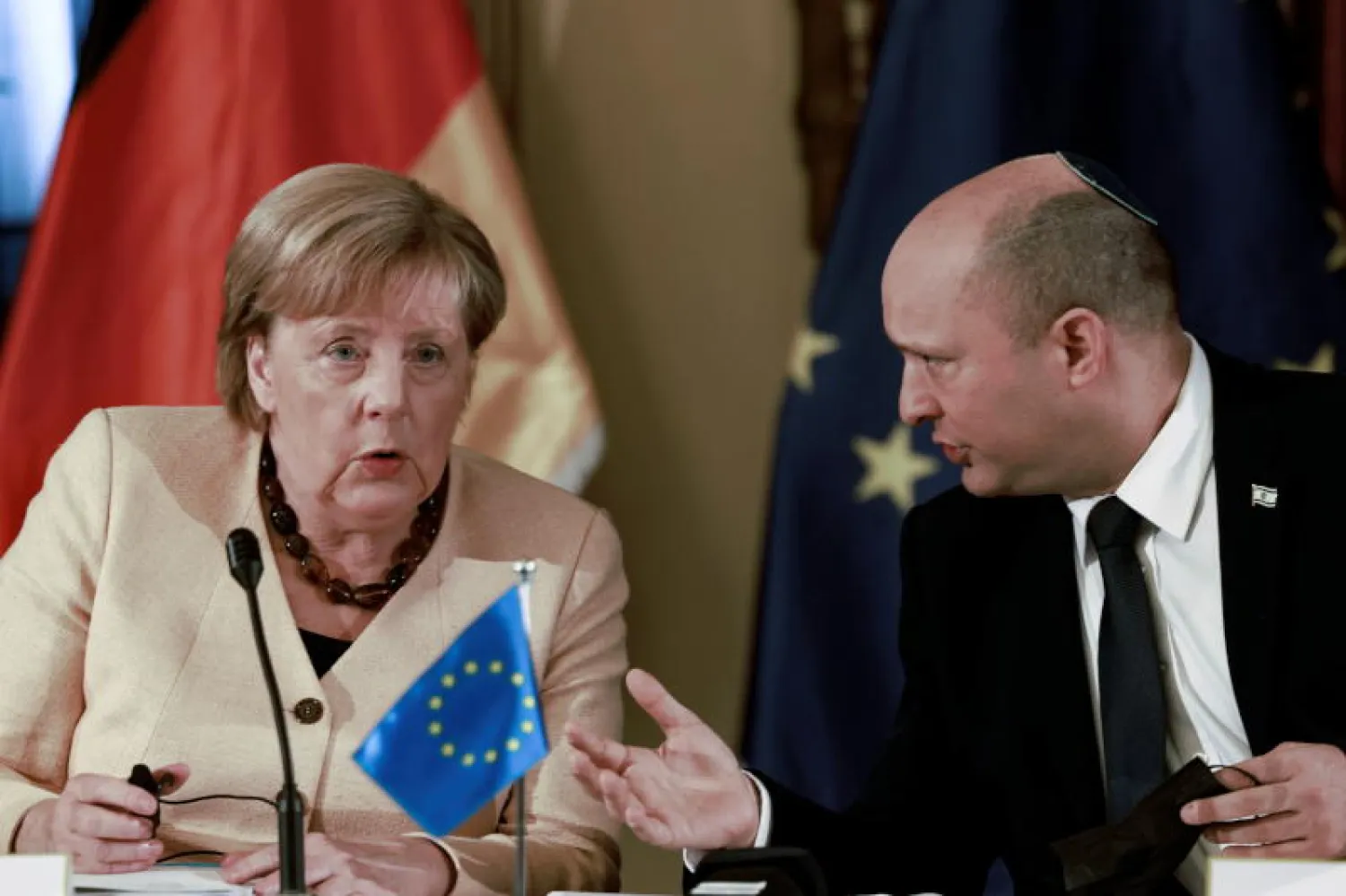 رئيس الوزراء الإسرائيلي نفتالي بنيت والمستشارة الألمانية أنجيلا ميركل خلال اجتماعهما اليوم (رويترز)