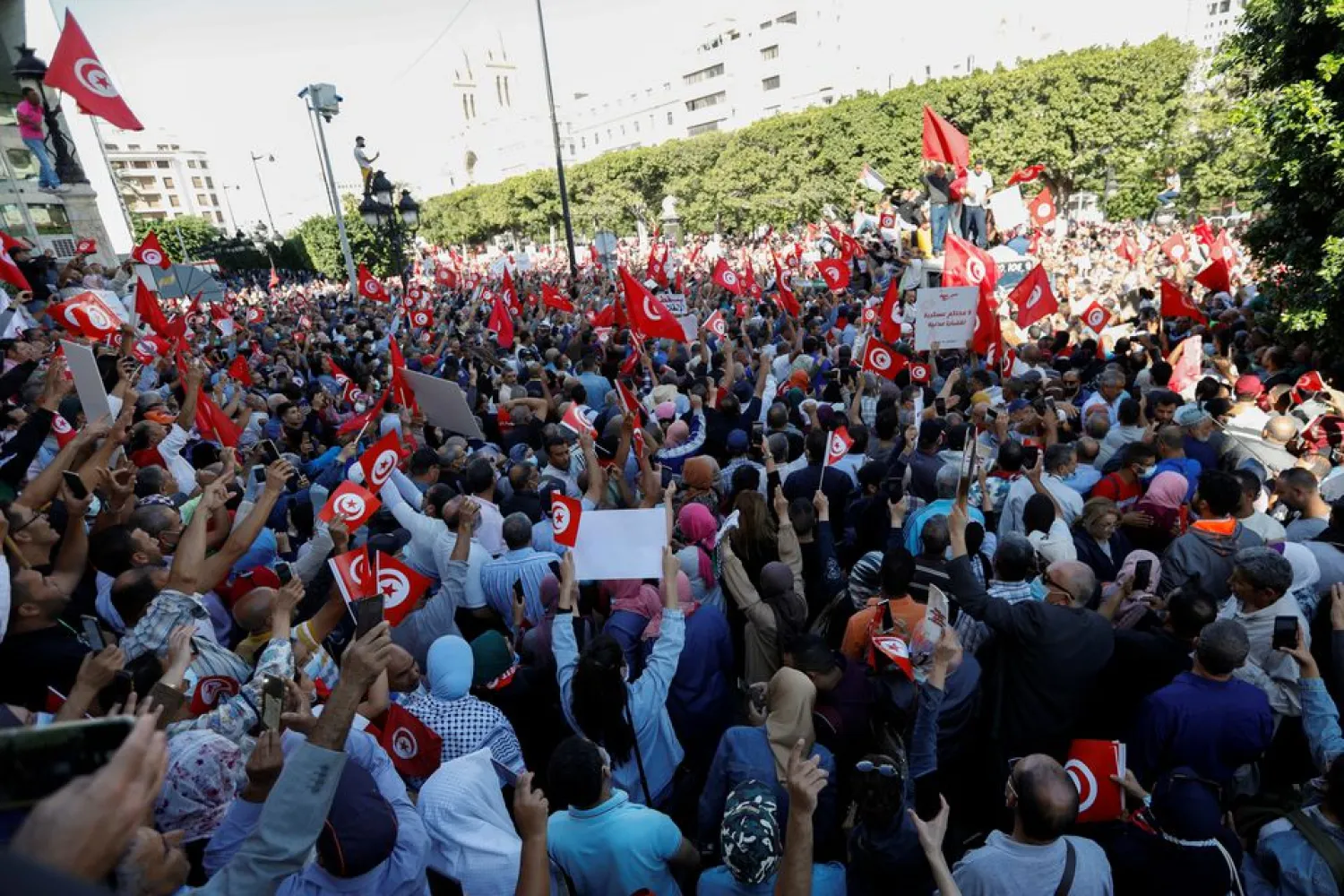Demonstrators carry flags and banners during a protest against Tunisian President Kais Saied's seizure of governing powers, in Tunis, Tunisia, October 10, 2021. (Reuters)