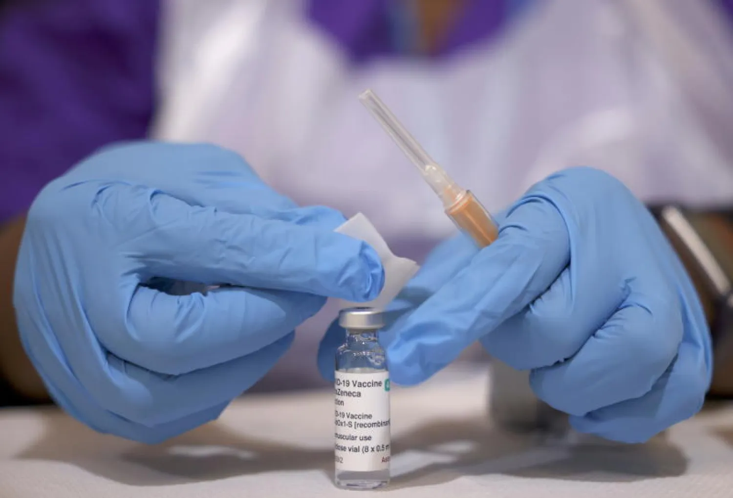 ممرض يحضر جرعة من لقاح «أسترازينيكا» في مركز للتطعيم بلندن (رويترز)