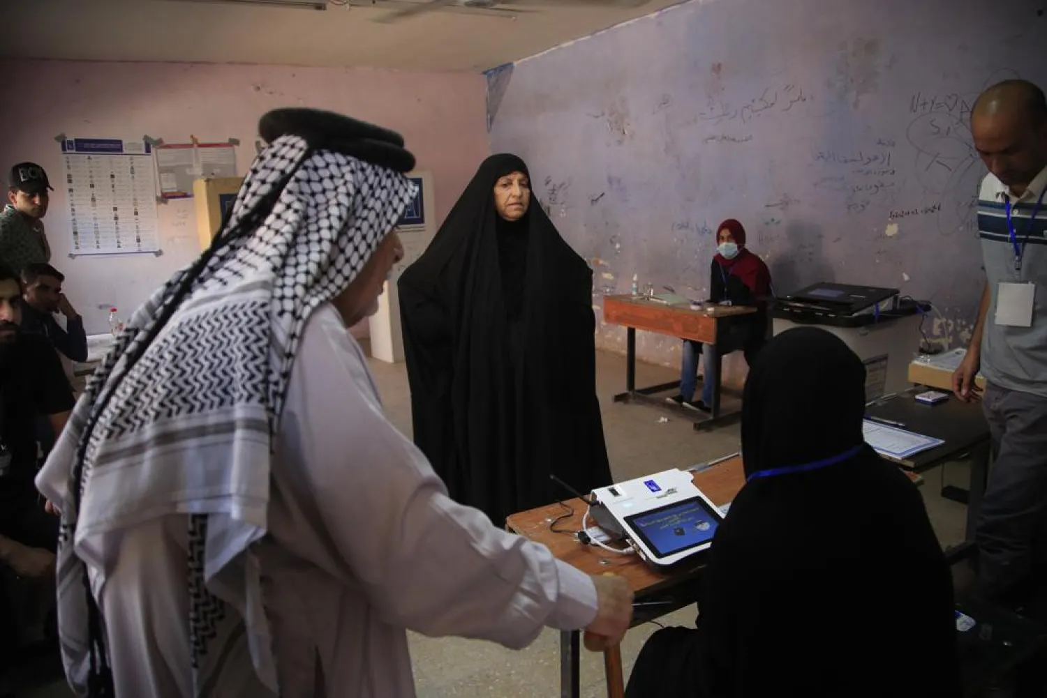 Iraqis gather to cast their vote at a ballot station in the country's parliamentary elections in Baghdad, Iraq, Sunday, Oct. 10, 2021. (AP)