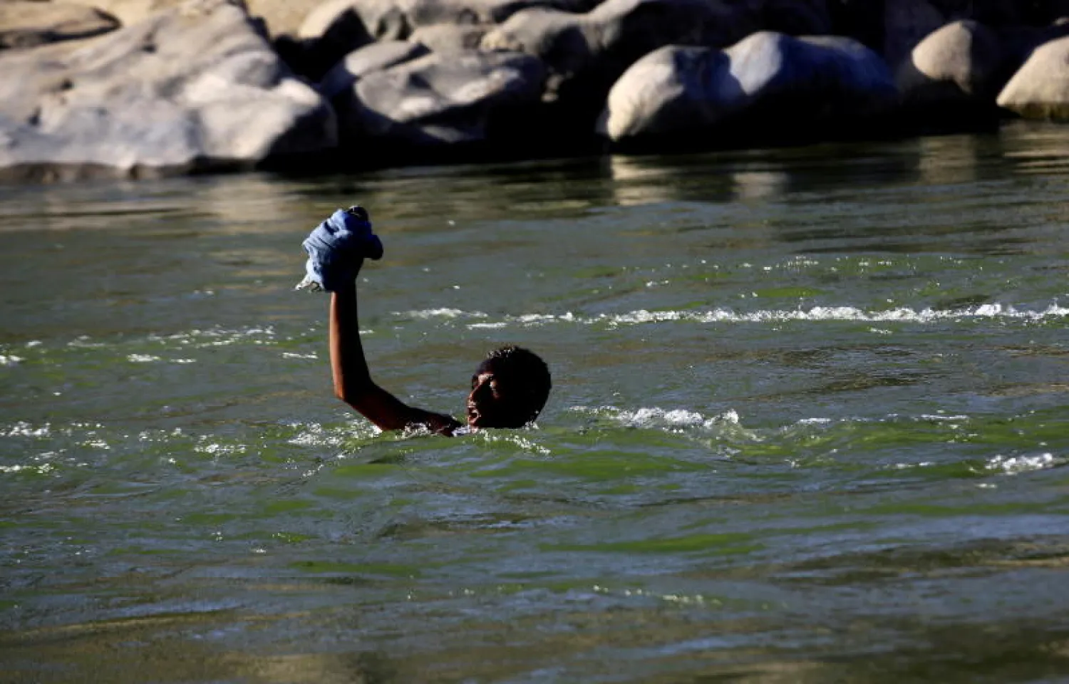 إثيوبي يعبر نهر سيتيت سباحة في اتجاه السودان هرباً من القتال (رويترز)