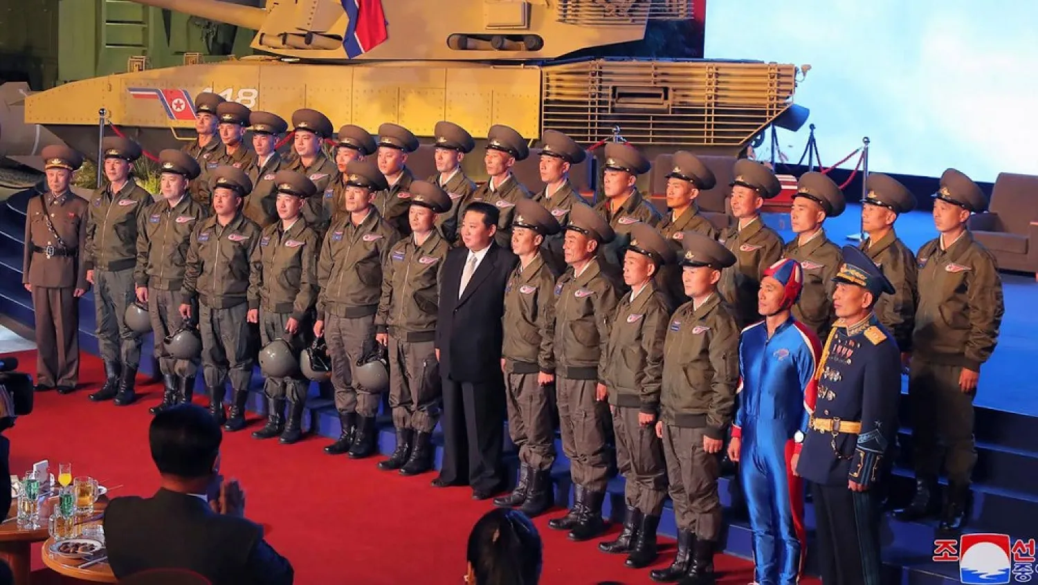 In this photo provided by the North Korean government, North Korean leader Kim Jong Un, center, poses for a group photo with fighter pilots who made the demonstration flight at the opening of an exhibition of weapons systems in Pyongyang, North Korea, Monday, Oct. 11, 2021. (Korean Central News Agency/Korea News Service via AP)
