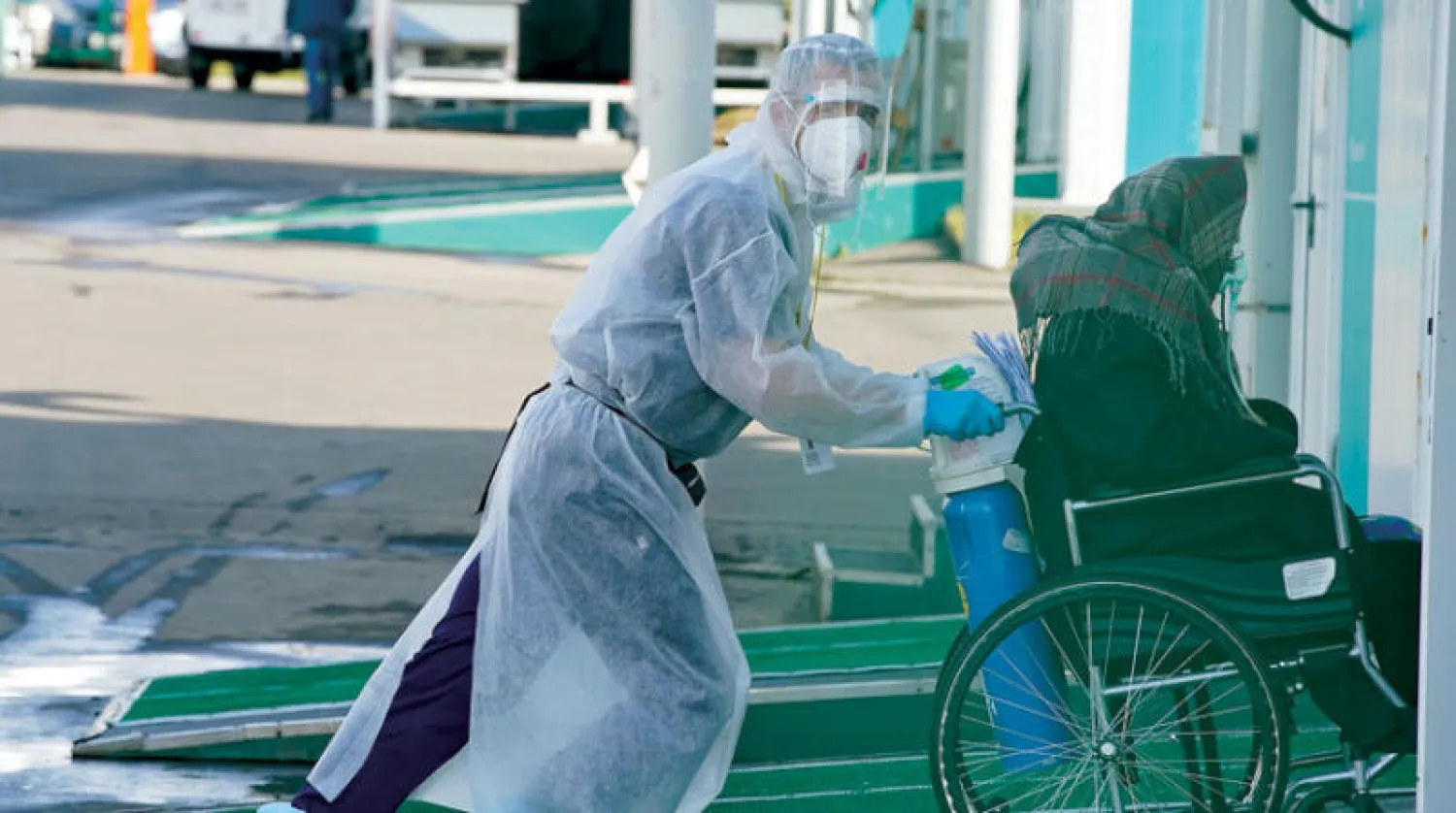 كادر صحي ينقل مصاباً بـ«كورونا» إلى مستشفى بموسكو أول أمس (رويترز)