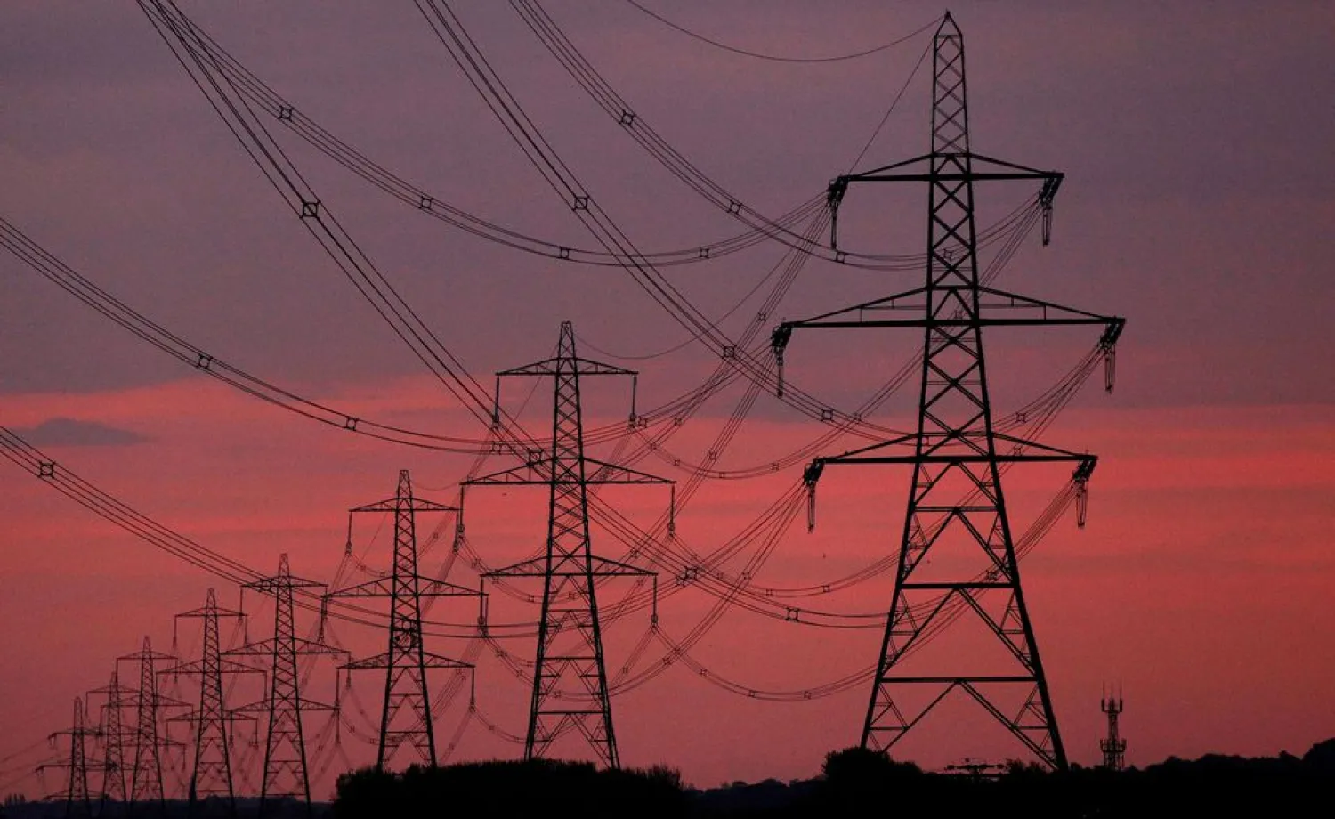 The sun rises behind electricity pylons near Chester, northern England October 24, 2011. REUTERS/Phil Noble/File Photo