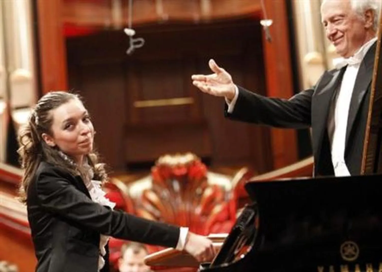 Yulianna Avdeeva of Russia acknowledges applause after performing with the The Symphonic Orchestra of the National Philharmonic conducted by Antoni Wit (R) during auditions of the finals of the 16th International Fryderyk Chopin Piano Competition in Warsaw October 19, 2010. REUTERS/Peter Andrews

