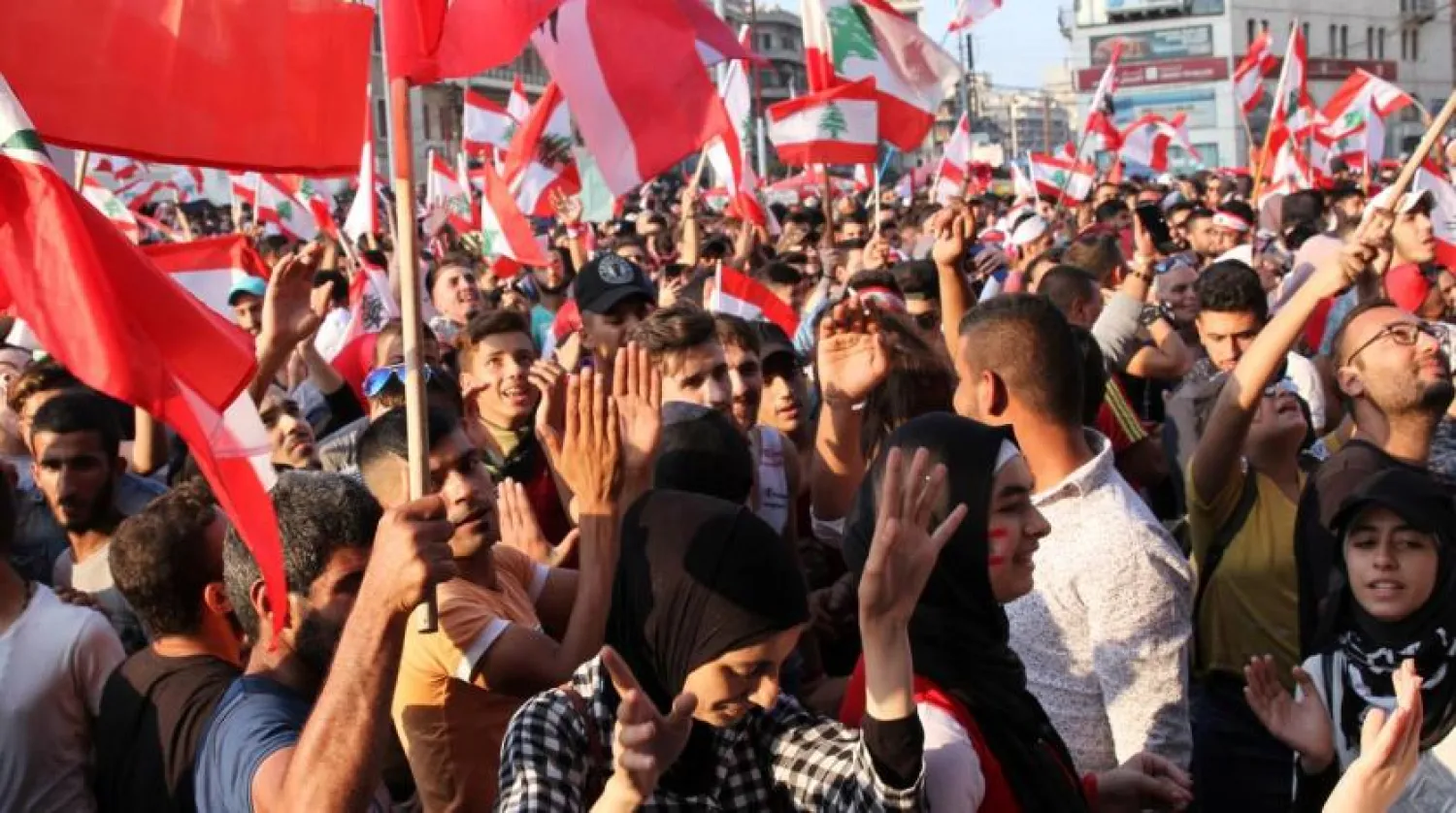 FILE: Demonstrators carry national flags during an anti-government protest in Tripoli, Lebanon October 21, 2019. REUTERS/Omar Ibrahim
