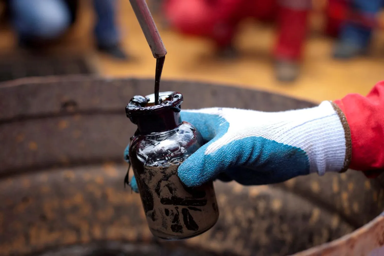 A worker collects a crude oil sample at an oil well operated by Venezuela's state oil company PDVSA in Morichal, Venezuela, July 28, 2011. REUTERS/Carlos Garcia Rawlins/File Photo