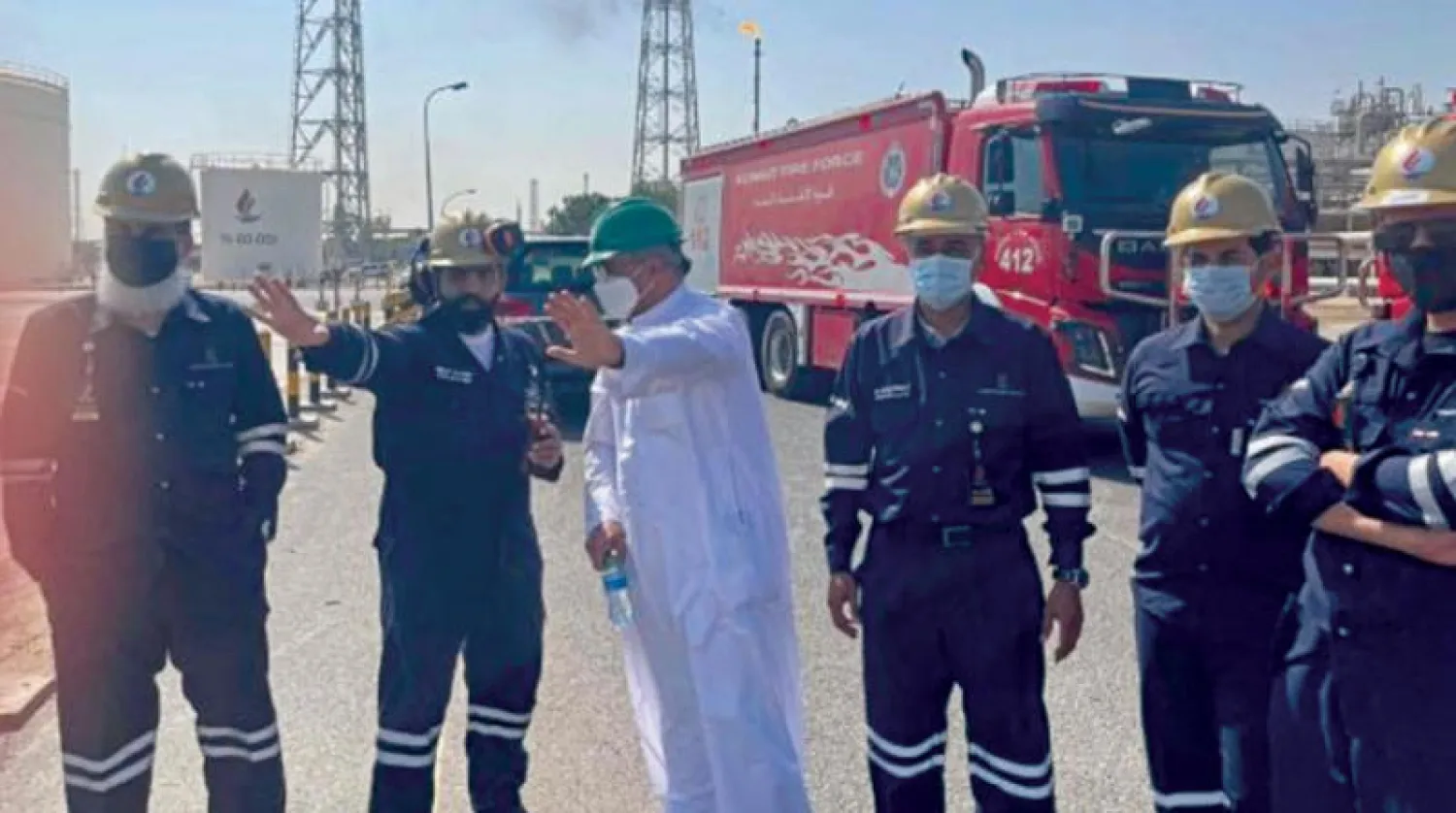 صورة بتثها شركة النفط الكويتية تظهر وزير النفط الكويتي محمد الفارس خلال التنسيق مع رجال الإطفاء في منشأة ميناء الأحمدي التي تعرضت لحريق أمس (أ.ف.ب)