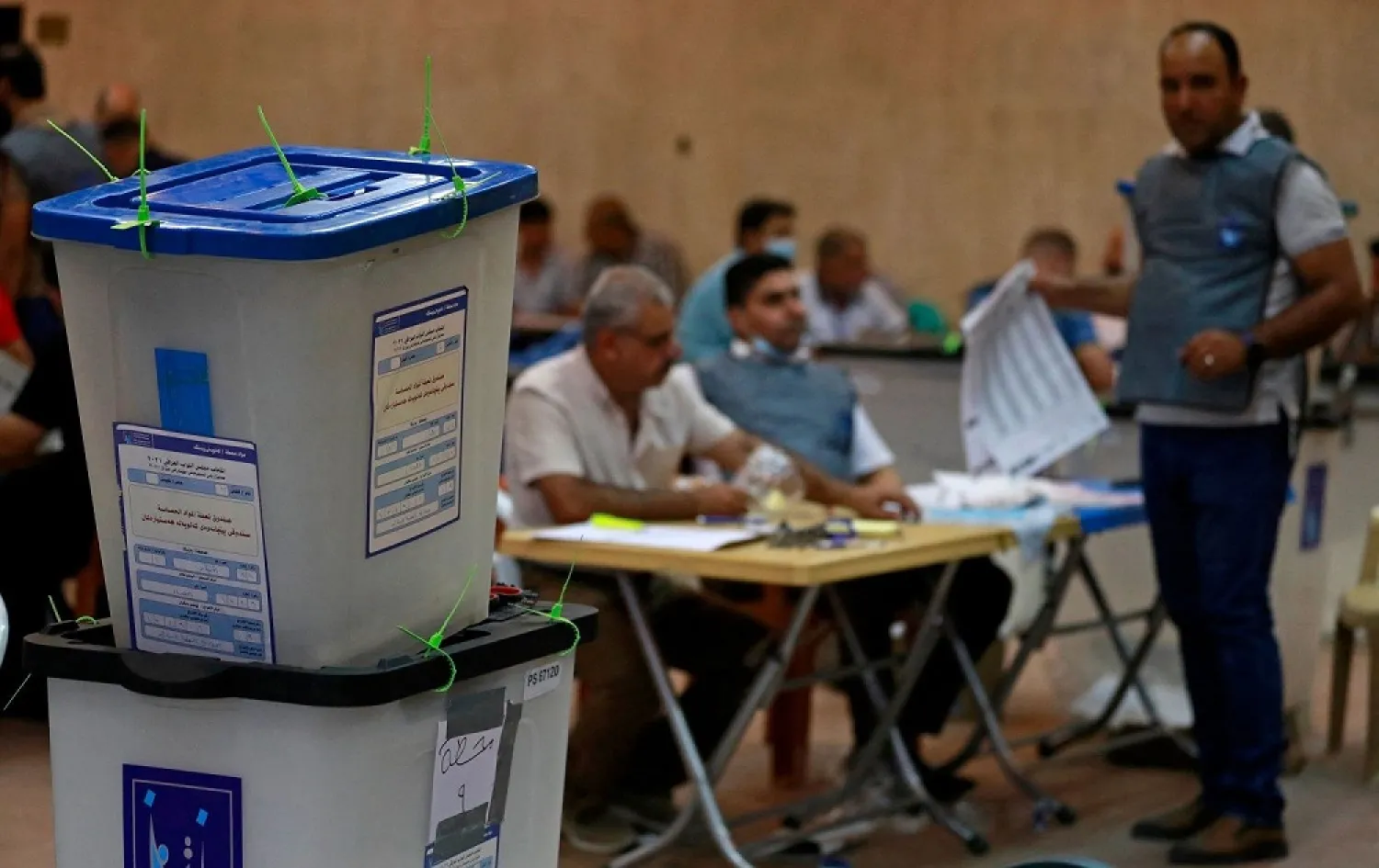Employees at Iraq’s Independent High Electoral Commission conduct a manual vote count following the parliamentary elections in Baghdad’s Green Zone, October 13, 2021. (AFP)