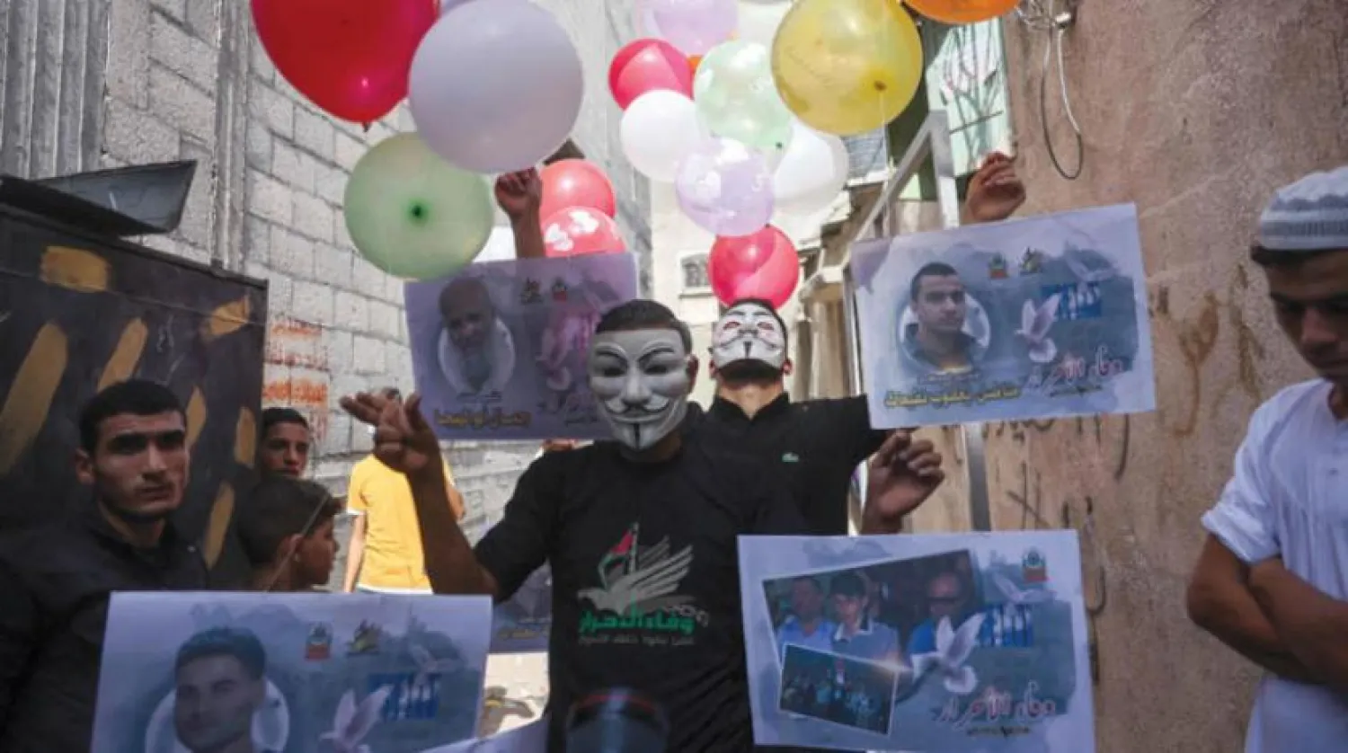  Demonstrators in Jabalia refugee camp in Gaza hold pictures of detainees in Israeli prisons (AFP).