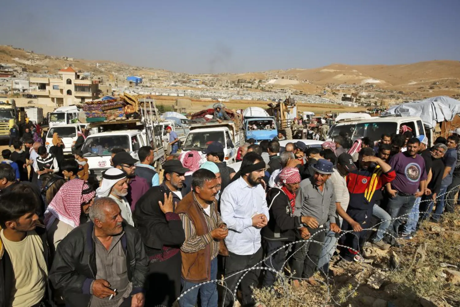 FILE - In this June 28, 2018 file photo, Syrian refugees gather in and near their vehicles getting ready to cross into Syria from the eastern Lebanese border town of Arsal, Lebanon. (AP Photo/Bilal Hussein, File)
