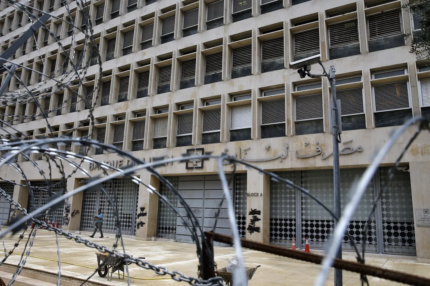 A worker walks outside the Lebanese Central Bank that has been shut down as part of the preventive measures against the coronavirus, in Beirut, Lebanon, March 18, 2020. (AP)